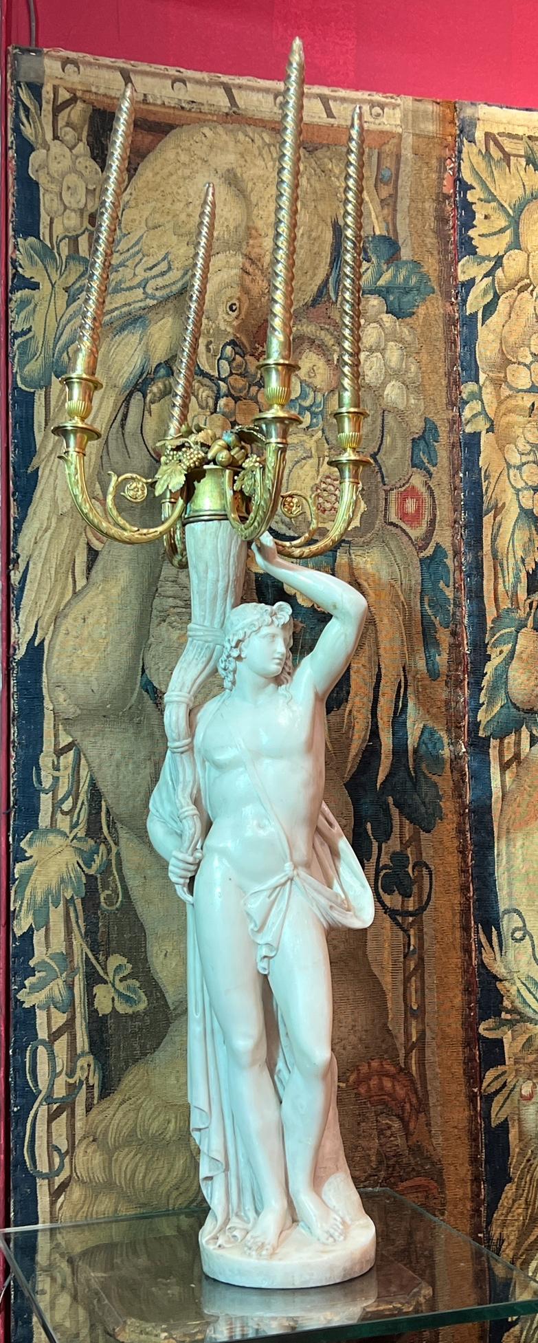 Our monumental pair of 18th century candelabra of French origin depict Roman neoclassical male and female holding cornucopia, finely carved from white marble, with four light ormolu bronze candleholders  of foliate design with fruits, nuts and grape