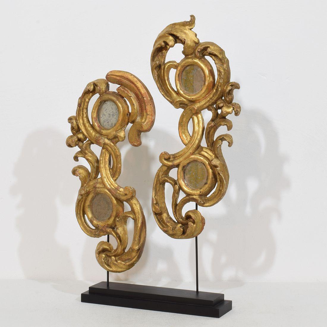 Beautiful pair handcarved and gilded baroque ornaments with small mirrors that once adorned a chapel or a church.
Despite of their high age in a relative good condition.
Italy, circa 1750. Weathered, small losses and old repairs. Measurement