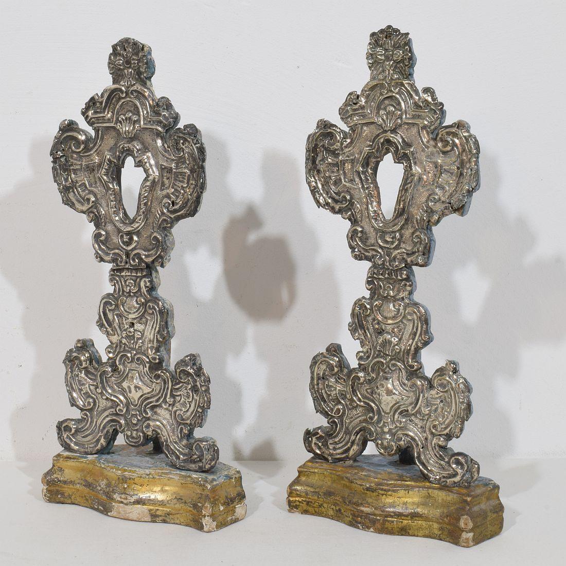 Bella e dettagliata coppia di porta reliquiari con un sottile strato d'argento martellato su legno. Bellissimi dettagli..,
Italia, circa 1750. Intemperie e piccole perdite.
Le misure sono individuali.
H. H. 41,5 cm  L:18,5 cm P:10 cm 