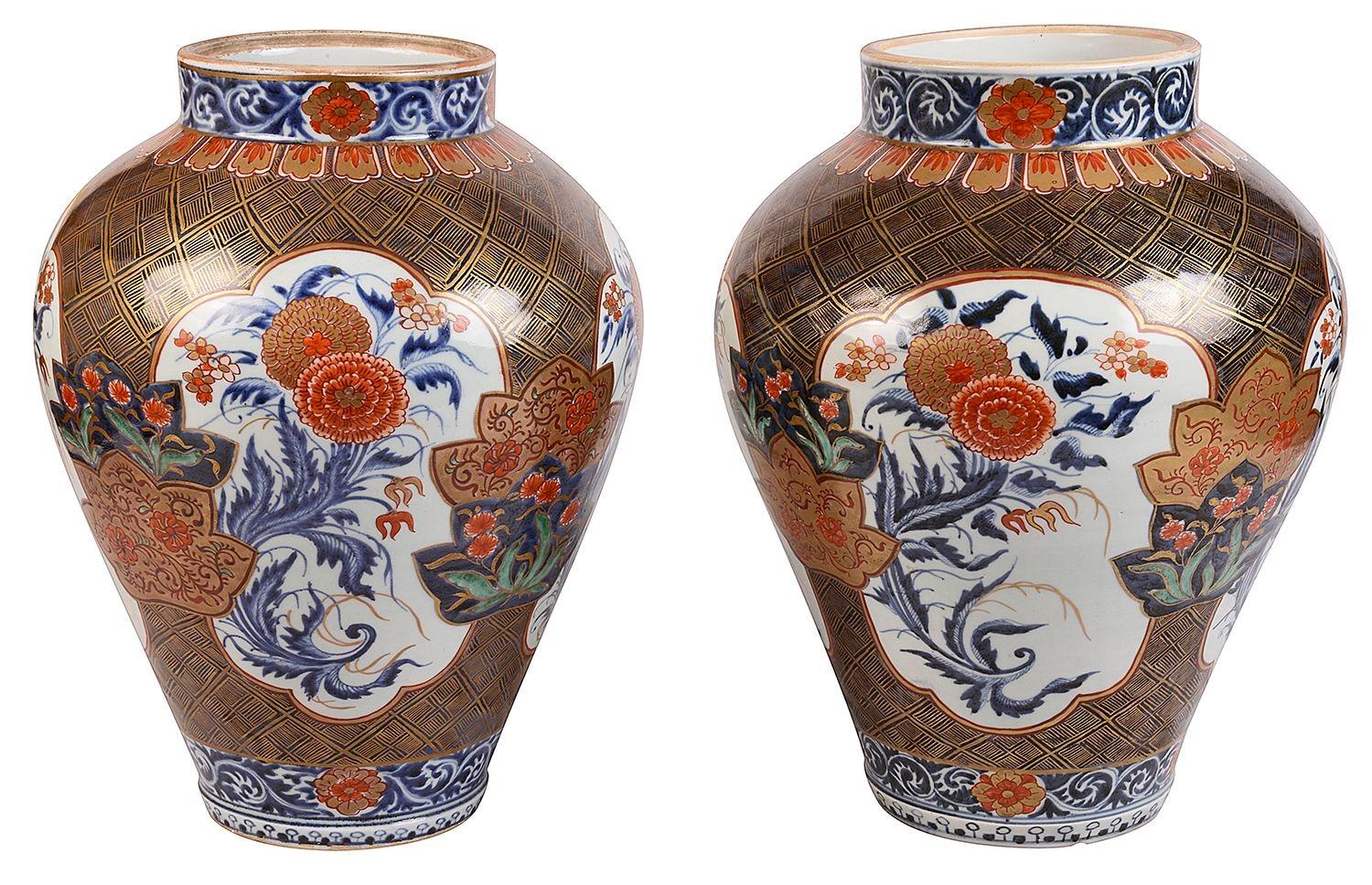 Ein wundervolles Paar japanischer Arita-Porzellan-Imari-Vasen aus dem späten 18. Jahrhundert, jede mit wundervoller, kräftiger Farbgebung, auf der Tafeln mit exotischen Blumen auf einem Grund mit klassischen Motiven abgebildet sind, um