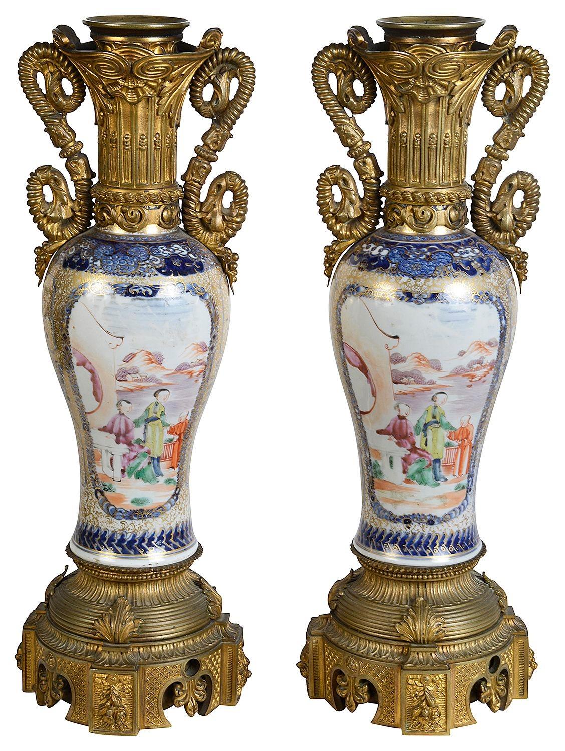 Llamativa pareja de jarrones/lámparas de porcelana mandarina china del siglo XVIII, cada uno con fondo azul empolvado y decoración dorada. Paneles insertados pintados a mano que representan figuras en el jardín con montañas al fondo. Tiene unas