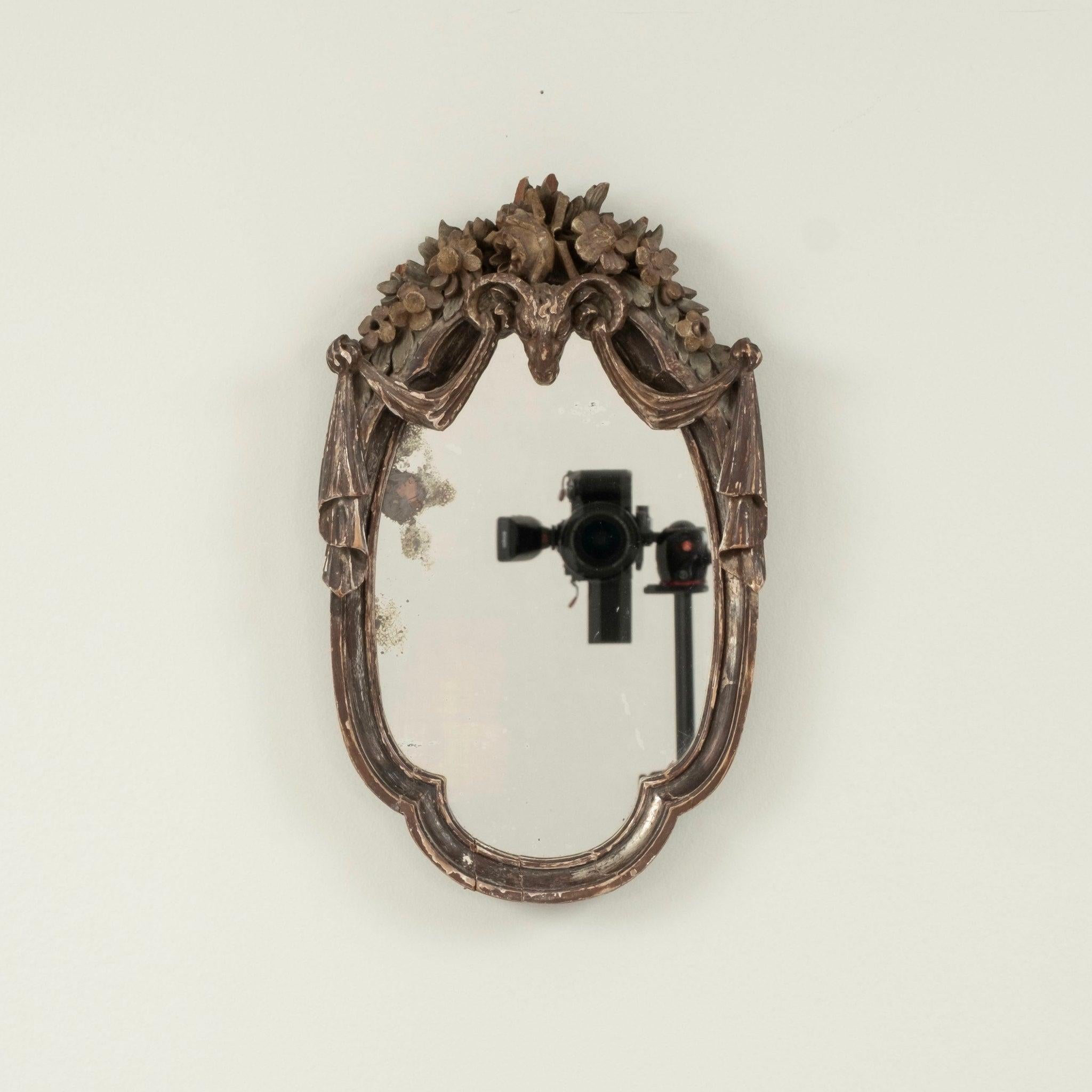 Coppia di specchi Luigi XV del XVIII secolo con cornici in legno ornate da motivi a testa di ariete, ghirlande floreali e foglie d'acanto.