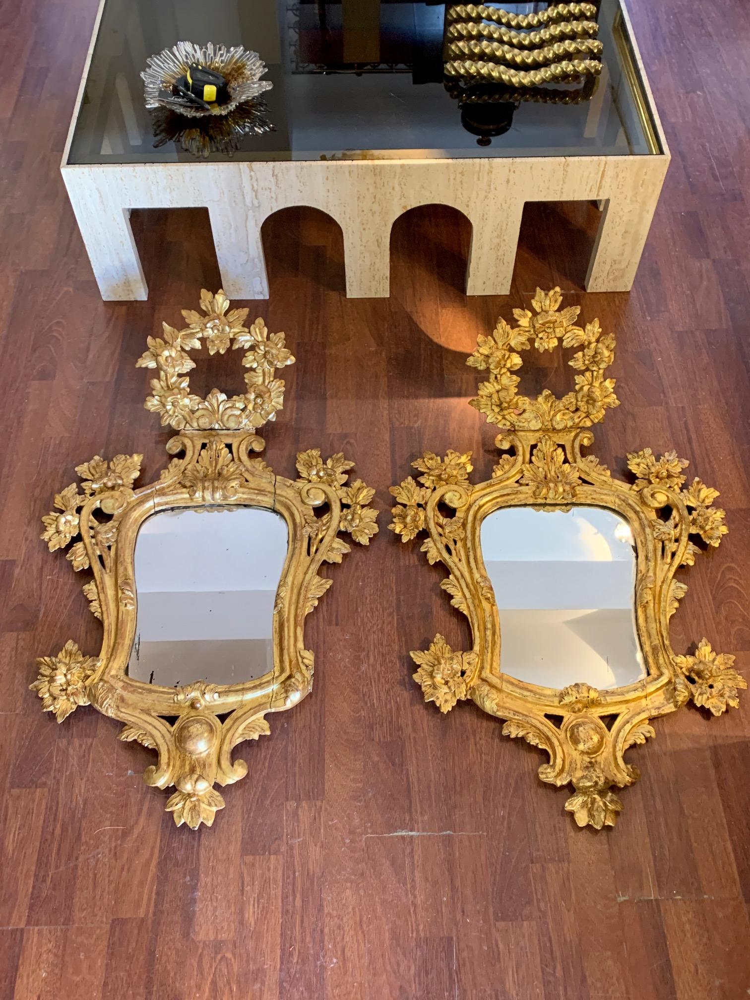 A pair of Spanish carved giltwood mirrors, 18th century time of the reign of Charles III, beautiful naturalists and flowers motifs, gold leaf giltwood, decoration with scrolls , and shells too. With excellent aged patina, original mercury glass. One