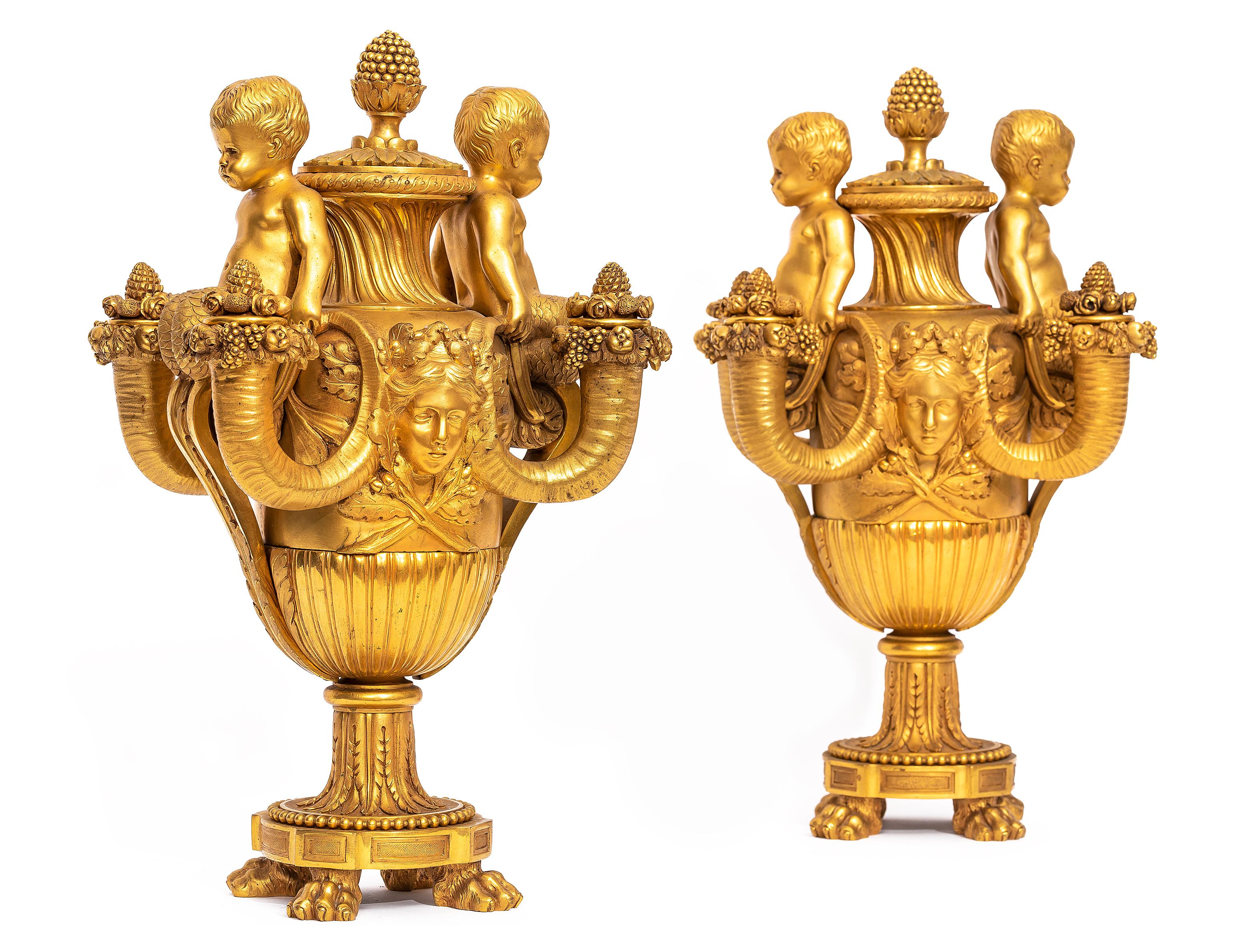 Coppia di candelabri/vasi a quattro bracci in ormolu francesi del XIX secolo con putti, su modello di Pierre Gouthière, attribuiti a Henry Dasson.
Ogni candelabro ha la forma di un vaso con coperchio, con un collo scanalato a spirale e sormontato da