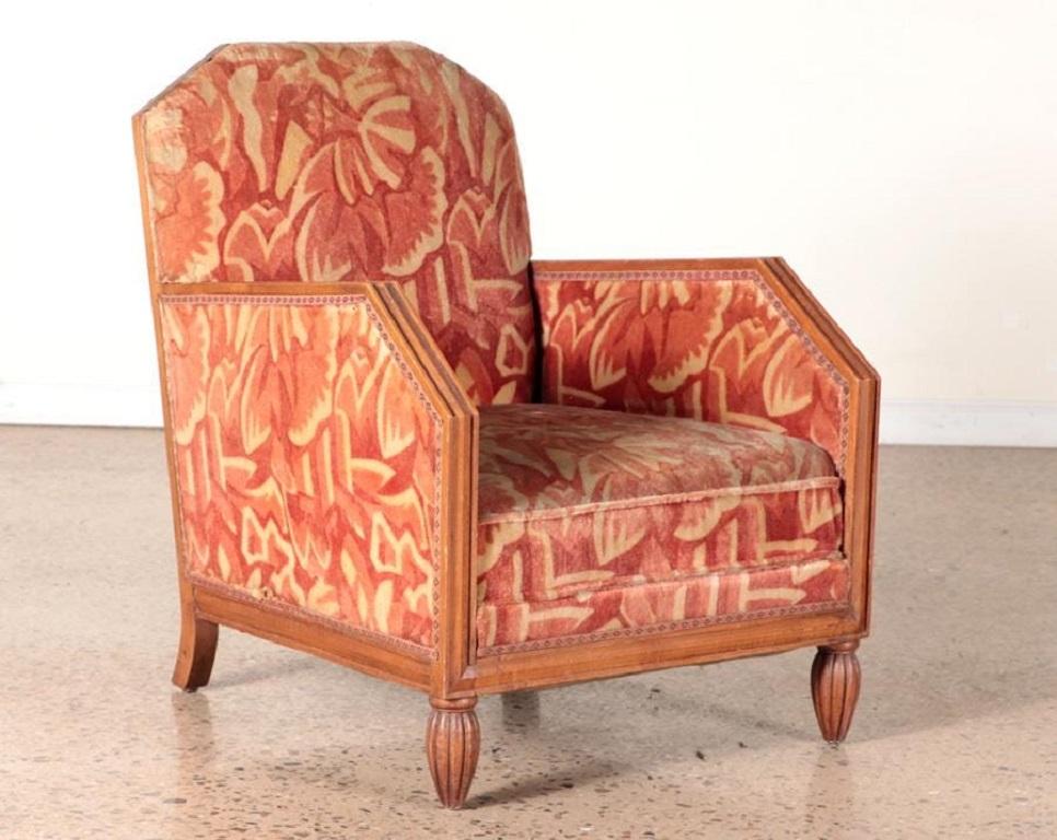 Pair of 1930s French Art Deco lounge chairs with matching ottomans in the manner of Paul Follot. The items have the original vintage upholstery with walnut frames.