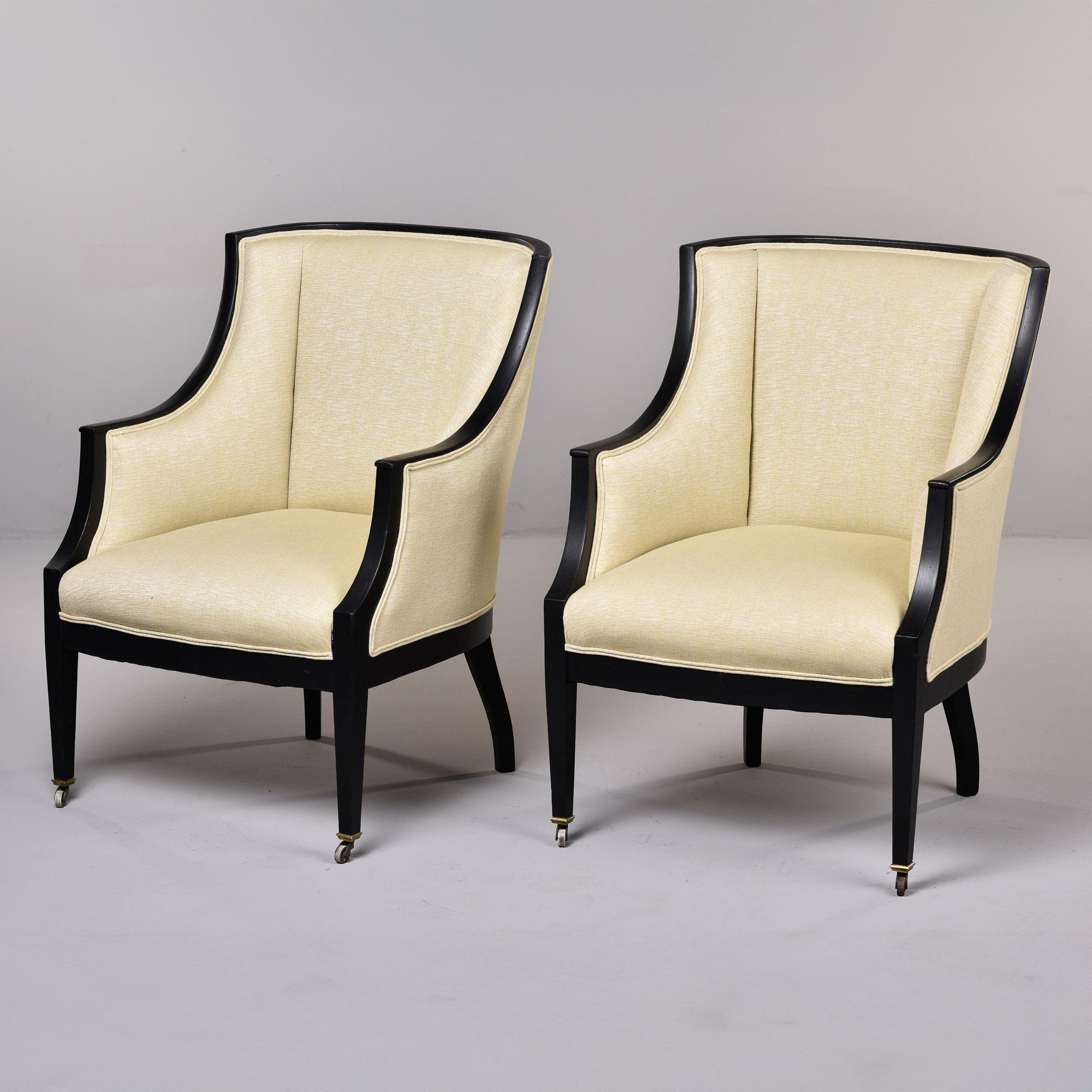 Trouvée en France, cette paire de fauteuils suédois date des années 1930. Cadre en bois dur aux lignes épurées avec finition peinte en noir et roulettes en laiton sur les pieds avant. Les chaises ont des dossiers et des sièges bien ajustés et ont