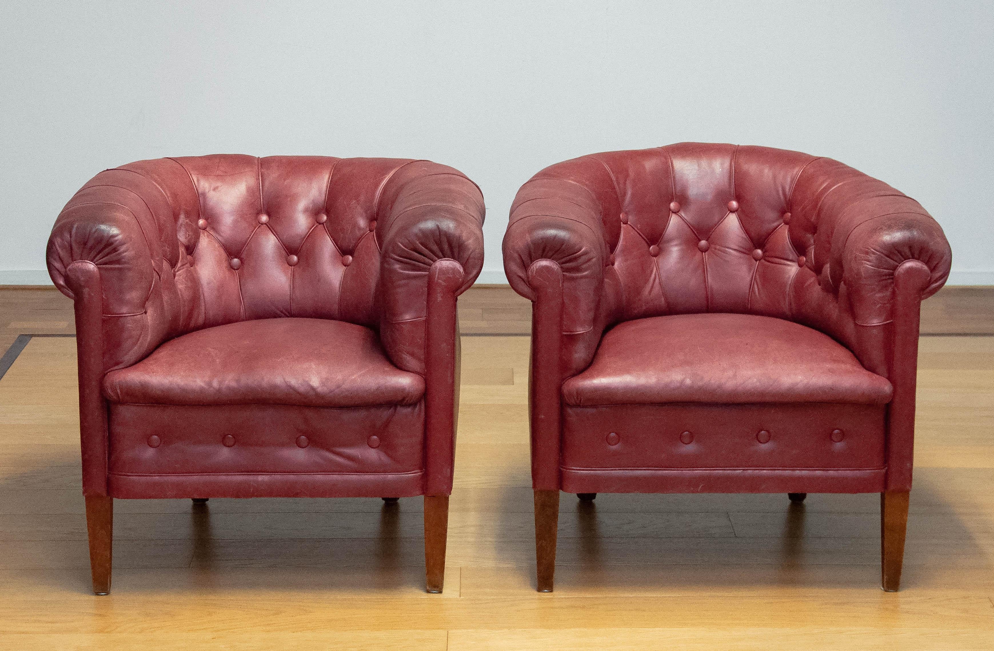 Pair beautiful crimson red club chairs made in the 1930s in Sweden. These chairs are both stil in original condition and therefor the leather has a great patina true the years. The condition of the leather is good and still very smooth. The springs,