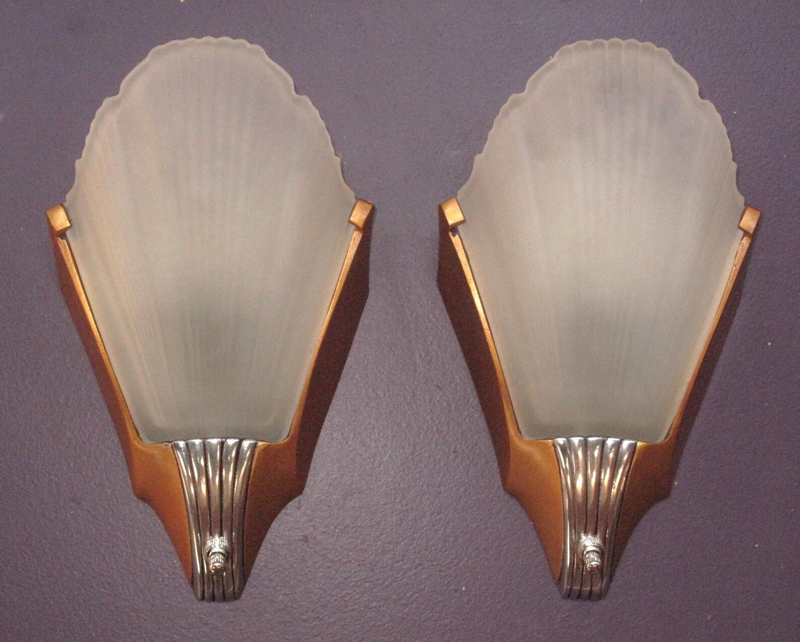 Priced per pair.
Although from the 1930s these slip shade wall fixtures are showing the distinct trend of what would become known as Mid-Century Modern. During the Great Depression manufacturers began to strip away the exuberant designs of the 1920s