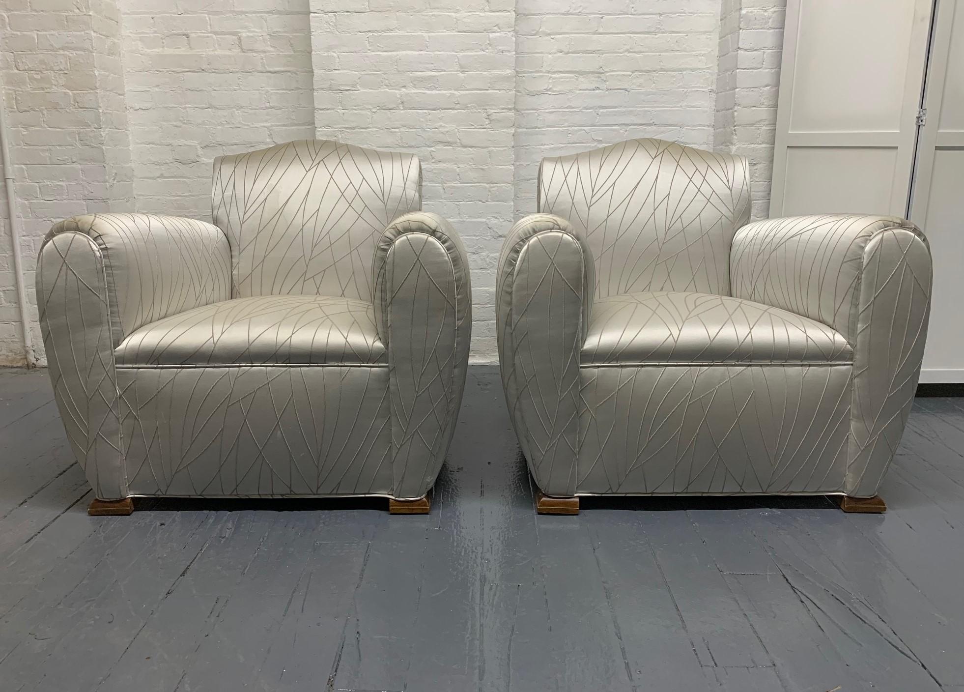 Pair of 1940s Art Deco lounge chairs. The chairs have walnut bracket feet and are oversized.