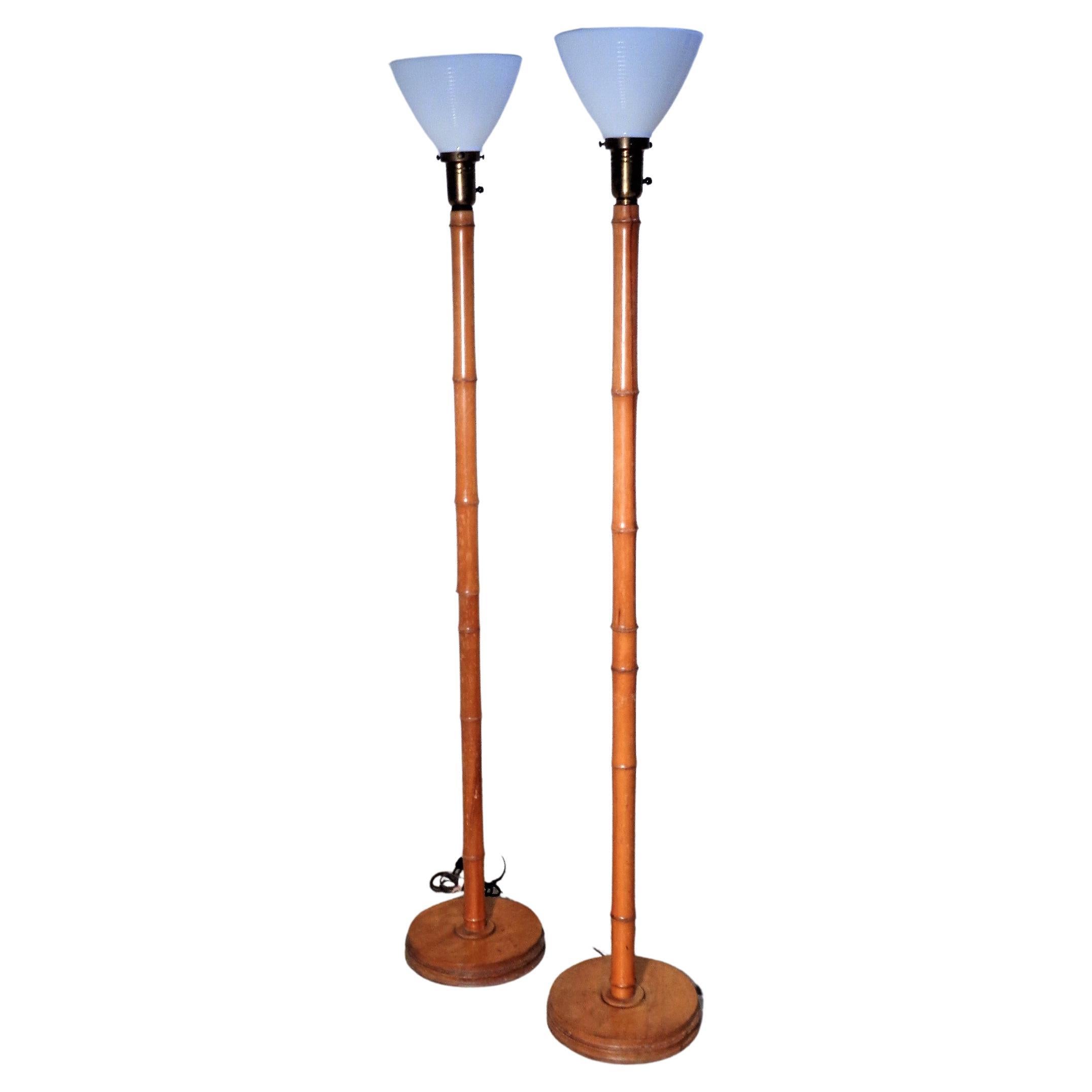 A pair of faux bamboo wood floor lamps in beautifully aged original honey colored surface w/ brass metal sockets and milk glass inserts. circa 1940s. Look at all pictures and read condition report in comment section. PRICE LISTED is FOR THE PAIR of