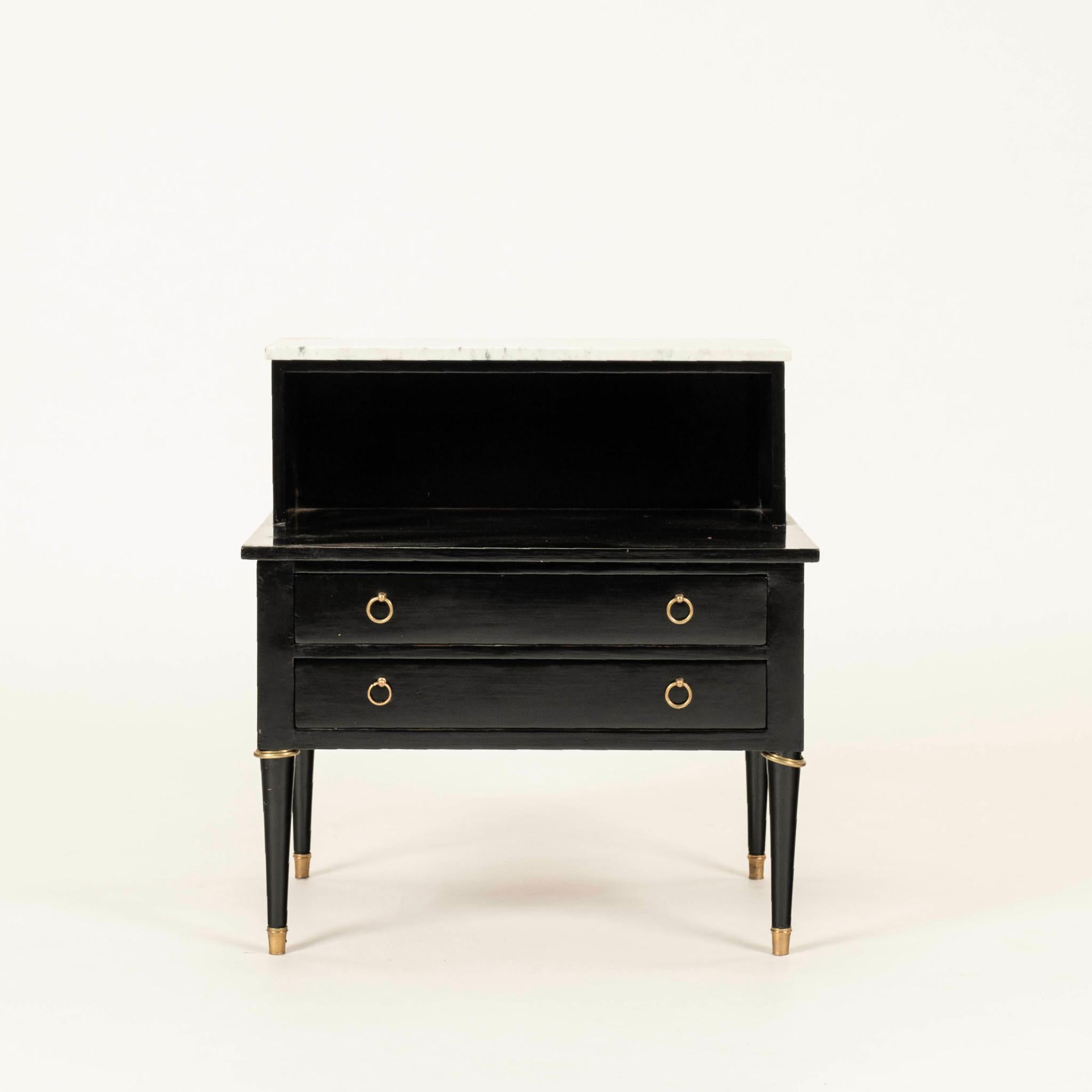 Pareja de mesas auxiliares francesas de estilo Directoire ebonizadas de los años 40, compuestas de madera lacada en negro, tapa de mármol blanco y herrajes y sables de latón.