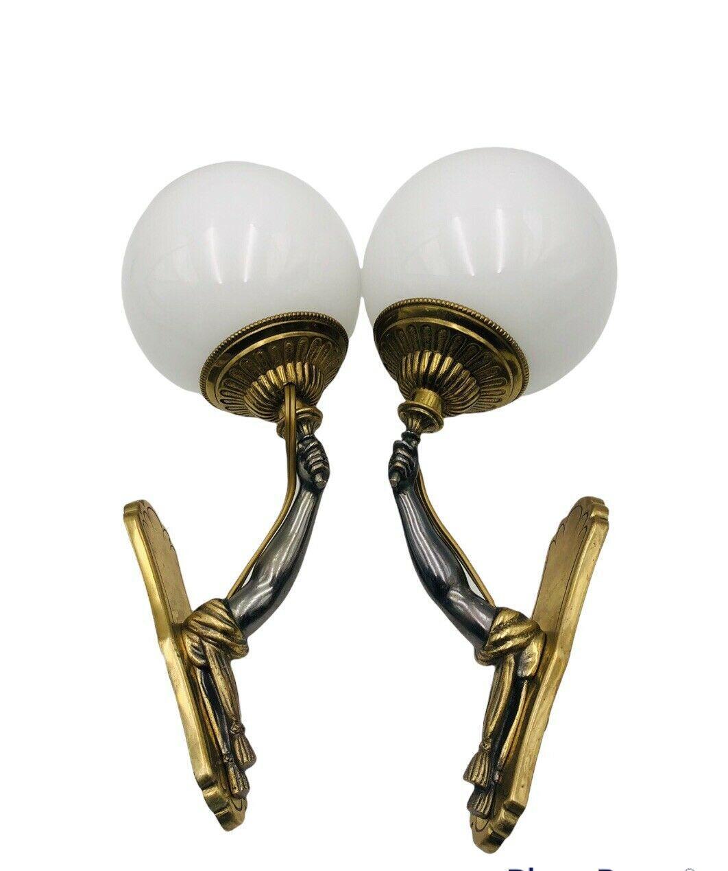 Pair 1940's Gilt Bronze Hollywood Regency Slender and Elegant Arm/ Fist Light Bearers. The outstretched arms are holding the light source. Opaline glass shades.