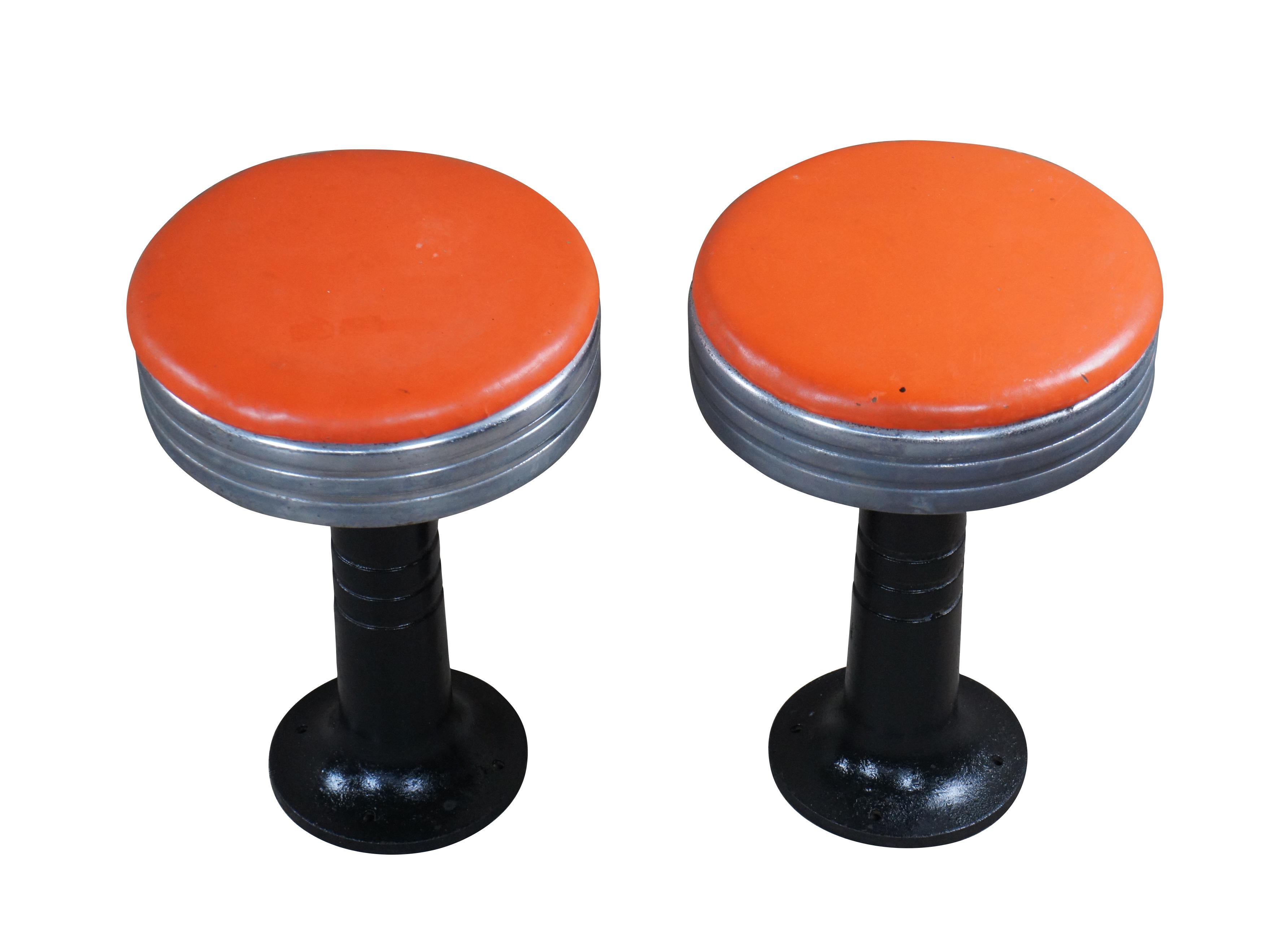 Paire de tabourets de fontaine / soda rétro Art déco tardif.  Fabriqué en chrome avec une base en fonte et un siège orange.  Chaque tabouret est pivotant.

Dimensions :
13 