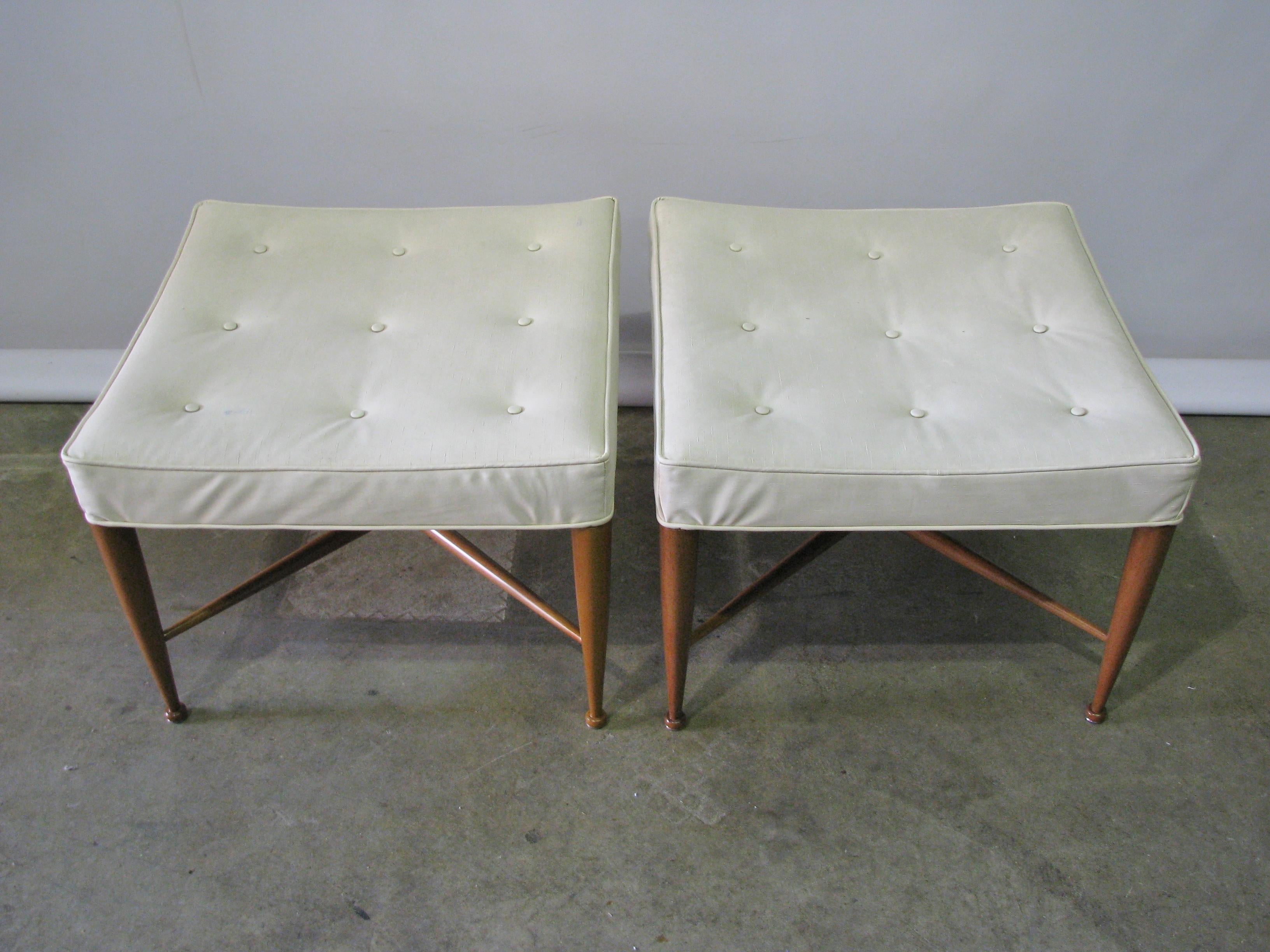 A pair of square upholstered benches each with a buttoned seat supported by walnut legs with button feet and X-stretchers. Model no. 5002. By Edward Wormley for Dunbar, American, circa 1950s. The pair has their original vinyl fabric (yes, vinyl!),