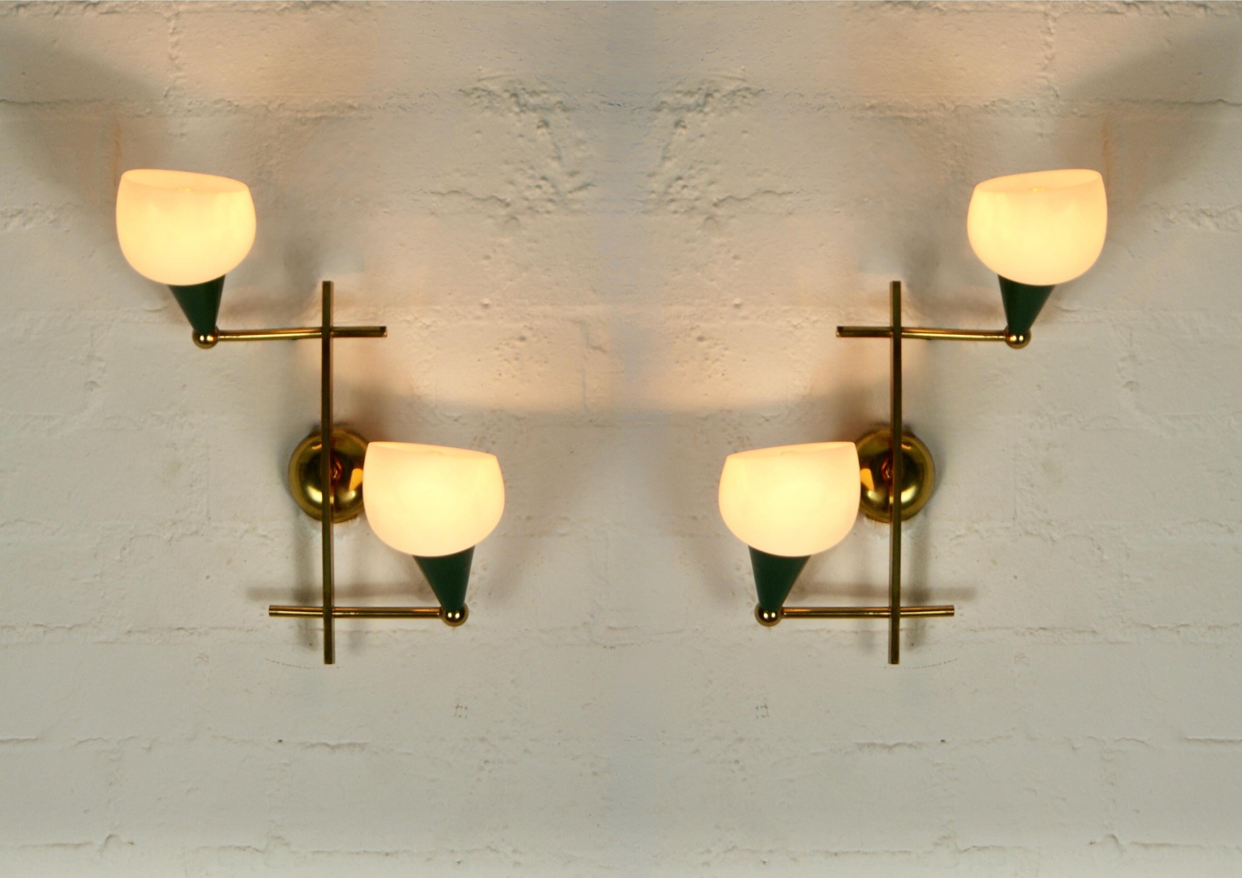 Pair of 1950s Italian made wall sconces.
In the manner of Stilnovo.
Crisscross of rectangular hollow and round solid brass rods make up the   frames.
Each lamp has 2 extending enamelled bulb bearing arms in green colour.
The difusers are of opaline