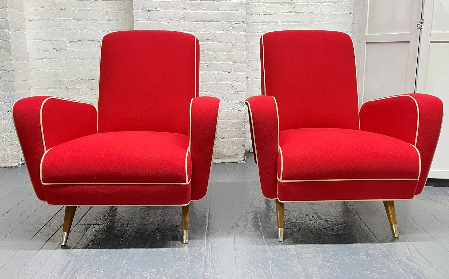 Pair 1950s Italian lounge chairs. The chairs have red felt upholstery and wooden legs. Legs have brass sabots.