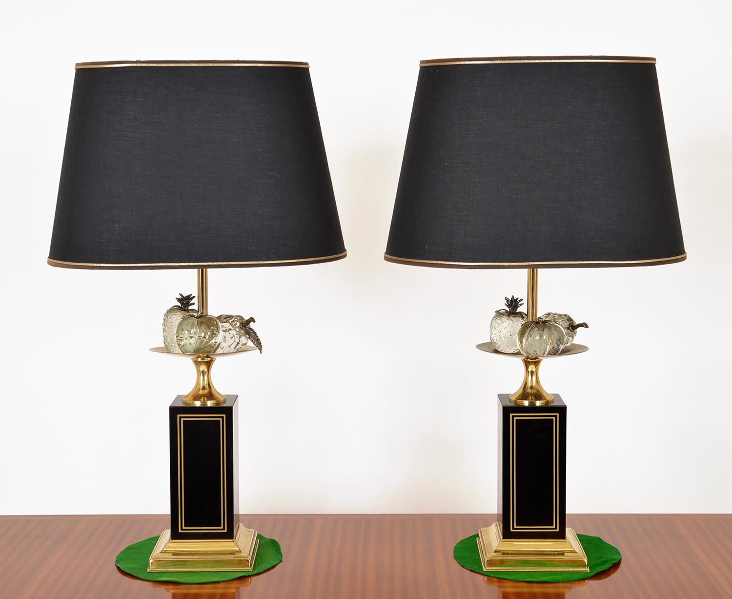 Stunning pair of tall decorative table lamps by Maison Charles, Paris. Raised square black enamelled columns with inlaid brass detail are raised on a stepped brass base. The column topped with a brass bowl holding beautifully cut crystal fruits with
