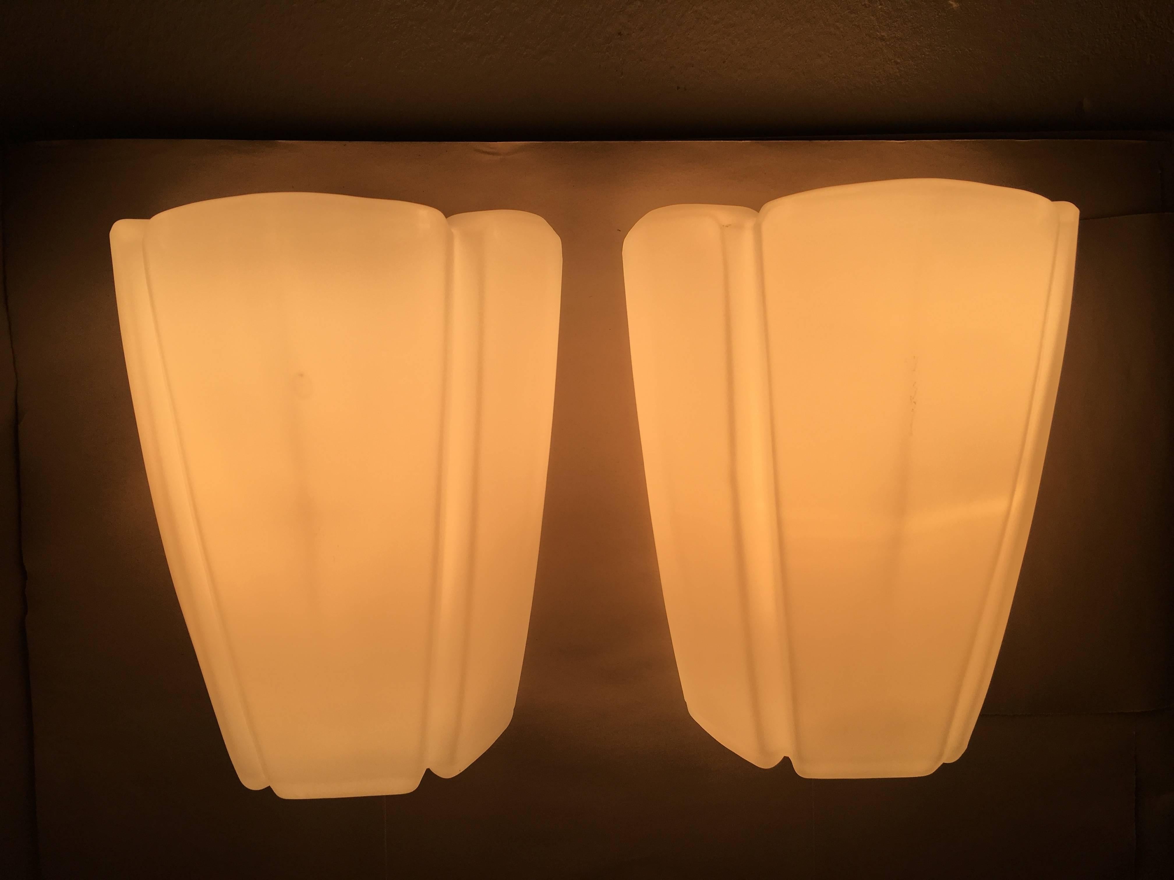Pair of sconces by Glashutte Limburg Germany, in the rare milk glass version. In good, working condition with on / off switch in the lamp, it works by pulling on the cord. Rewired to meet U.S. standards. Each fixture requires one European E27 Edison