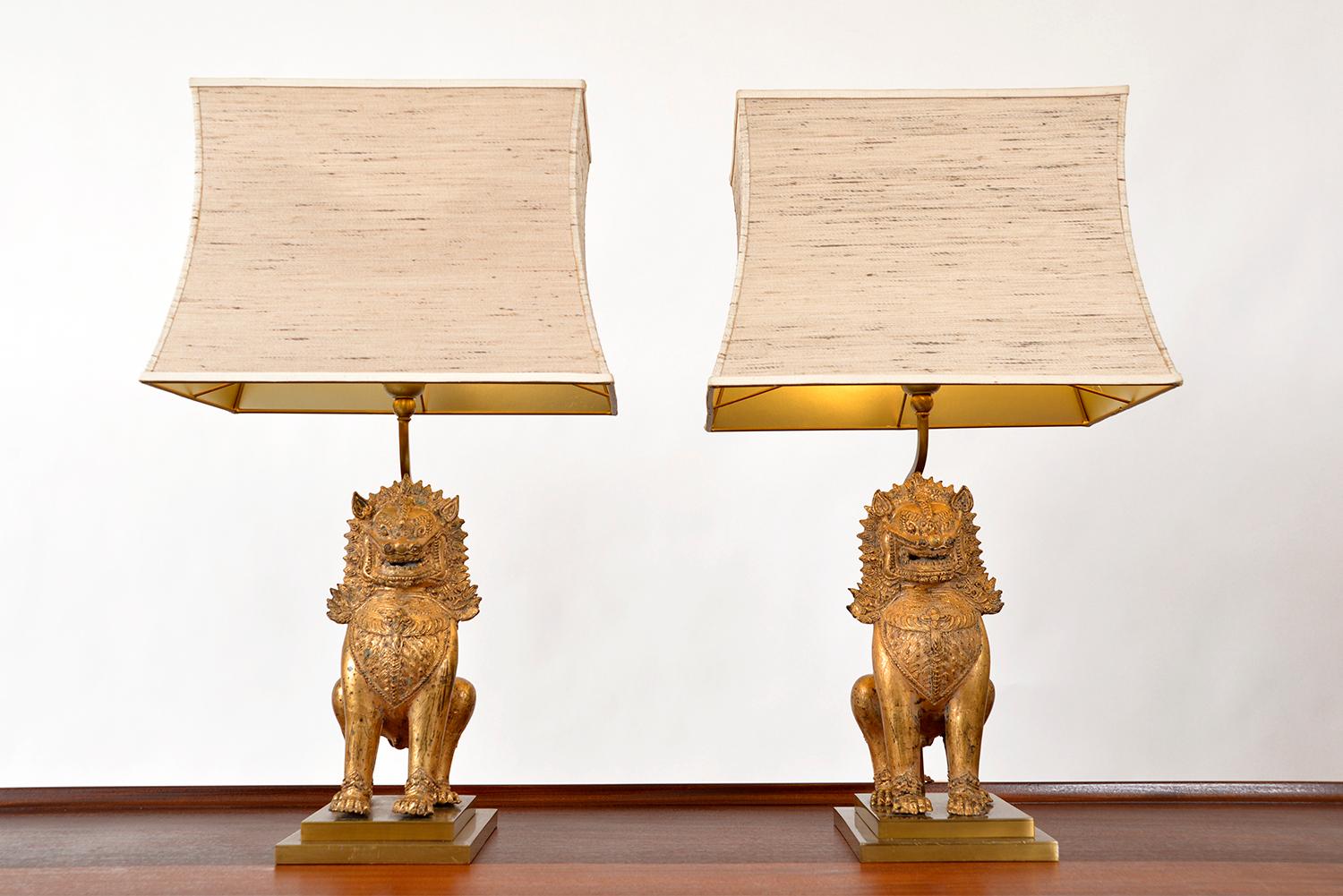 A highly decorative pair of 1960s Asian Dogs of Foo table lamps in a gilt chinoiserie finish, on stepped cast brass bases with original vintage Pergoda shades - very James Mont!
Both lamps have a period label to the base, indicating that they were