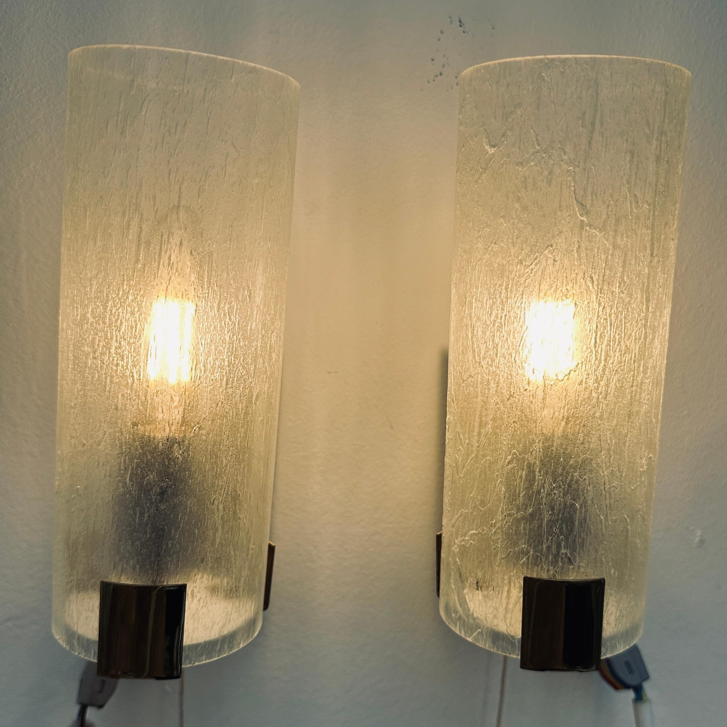 Pair of 1970s German frosted tubular glass wall light sconces on a gold plastic coated metal frame in the style of Doria Leuchten.  The mottled frosted glass tube sits on top of the frame and is held in place with a rectangular slot cut into the