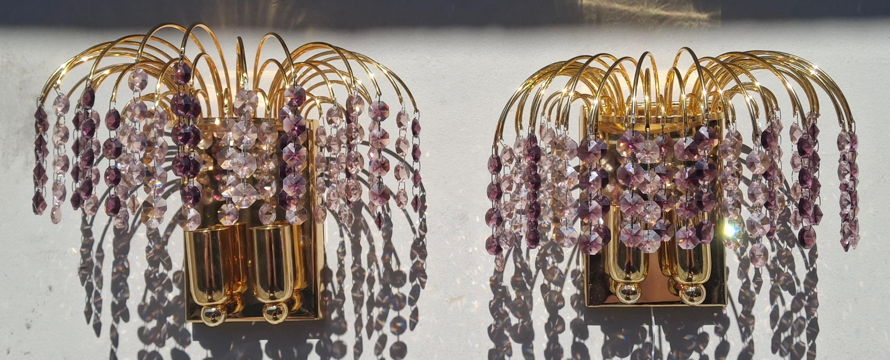 Paire d'appliques murales en cristal autrichien taillé en cascade, Vintage Hollywood Regency 1970, en 2 tons de cristal améthyste. Par Palwa. Cadres en métal doré. Opulentes appliques, toutes intactes et en très bon état. 2 lampes chacune.