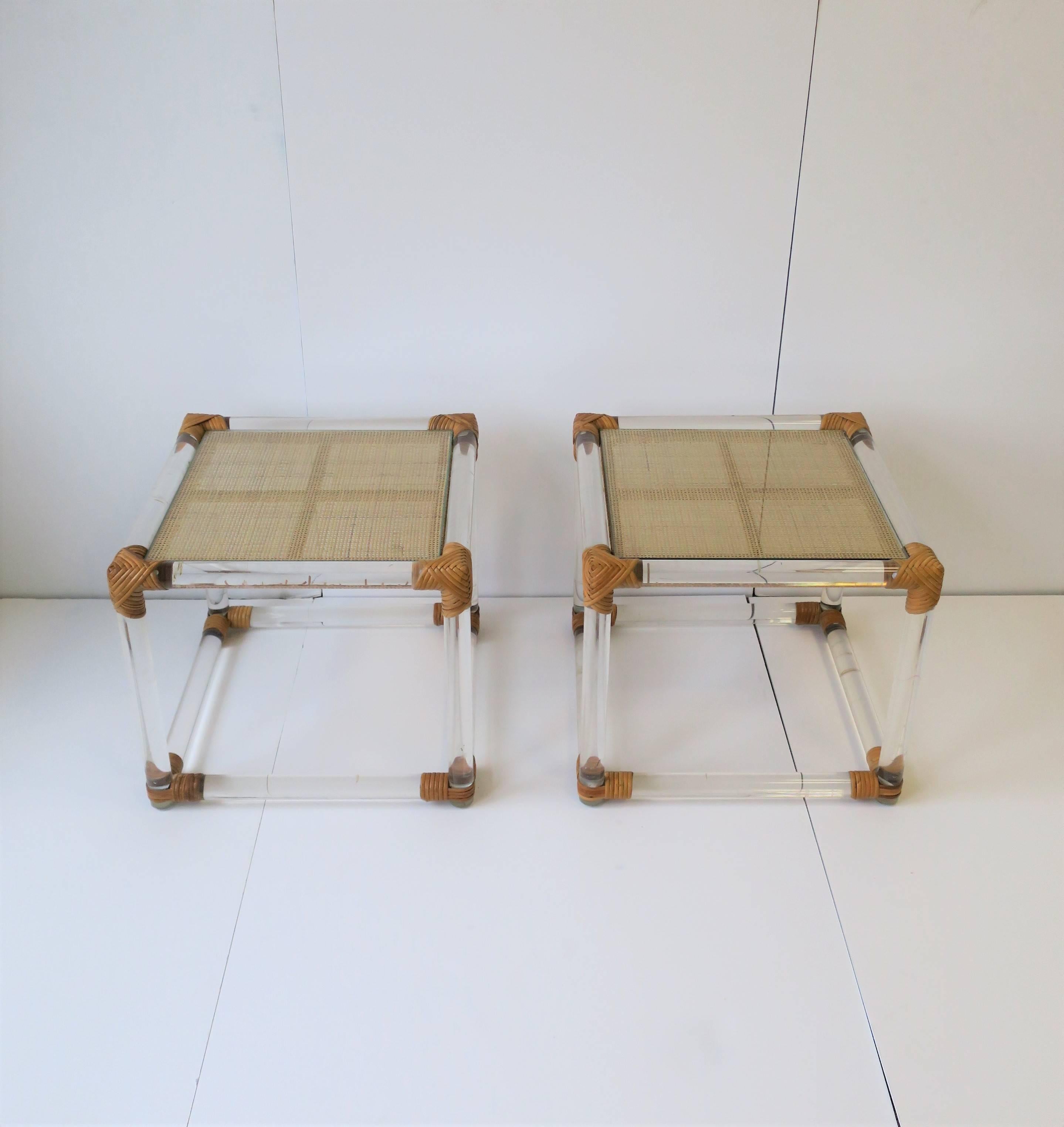 A pair of beautiful Postmodern or Modern style Lucite and wicker rattan end tables, or nightstand tables, circa late 1970s - 1980s. Tables have a wicker top with an inset glass top making for a stable environment. Glass and wicker tops are