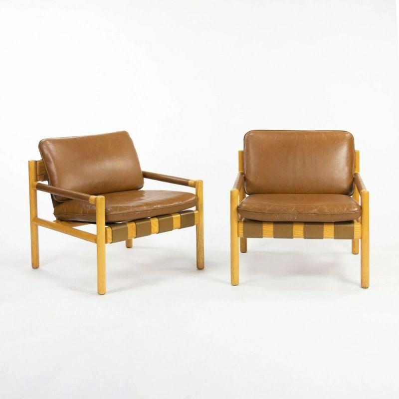Listed for sale is a pair of leather and oak Nicos Zographos Saronis lounge chairs from 1976, which came directly from a Hugh Stubbins (Architect) designed Library at a notable ivy-league institution. For context, additional provenance can be