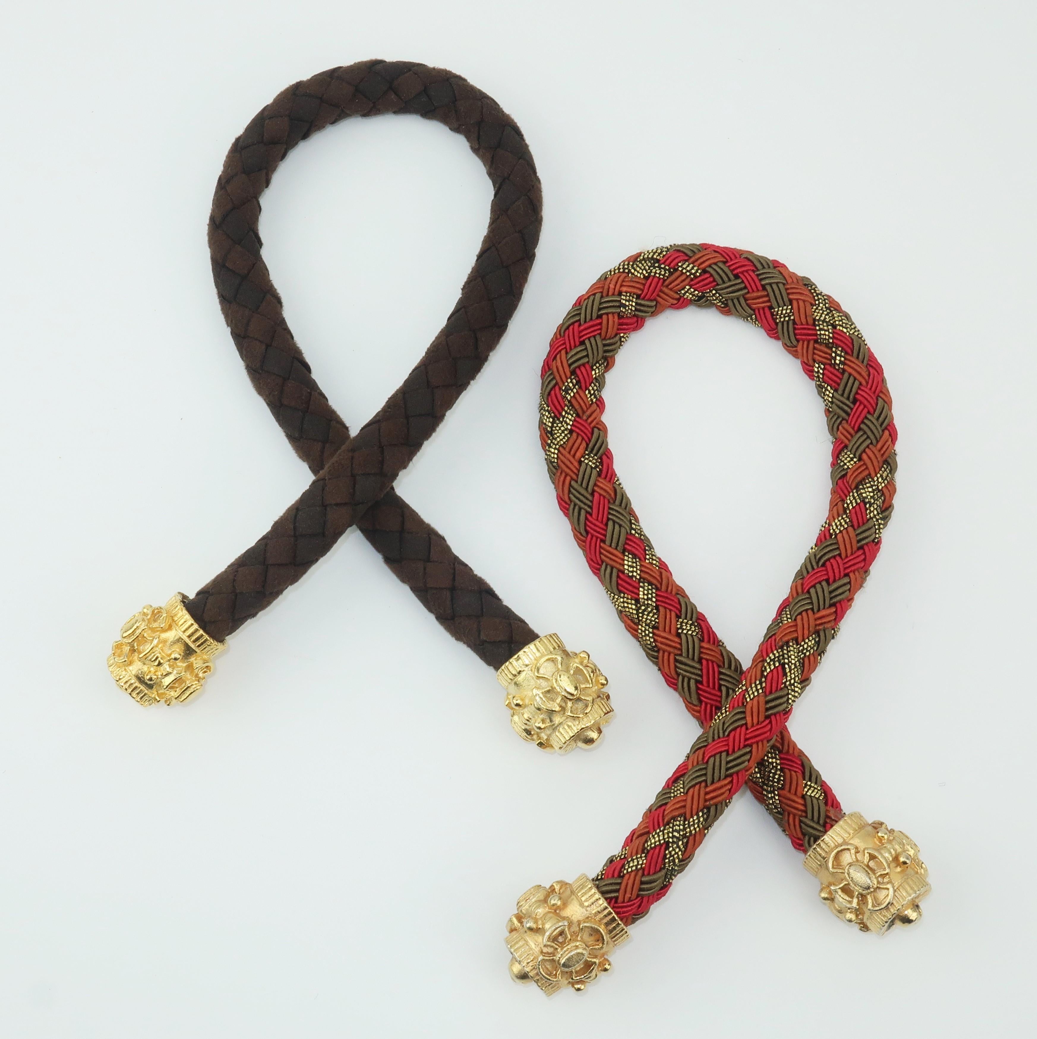 Put a little polish on your pony with these ornate hair ties.  Both pieces are braided with one in a brown ultra suede and the other in a olive green, red, rust and metallic gold silk cord.  Each end is accented with a weighty gold tip with a