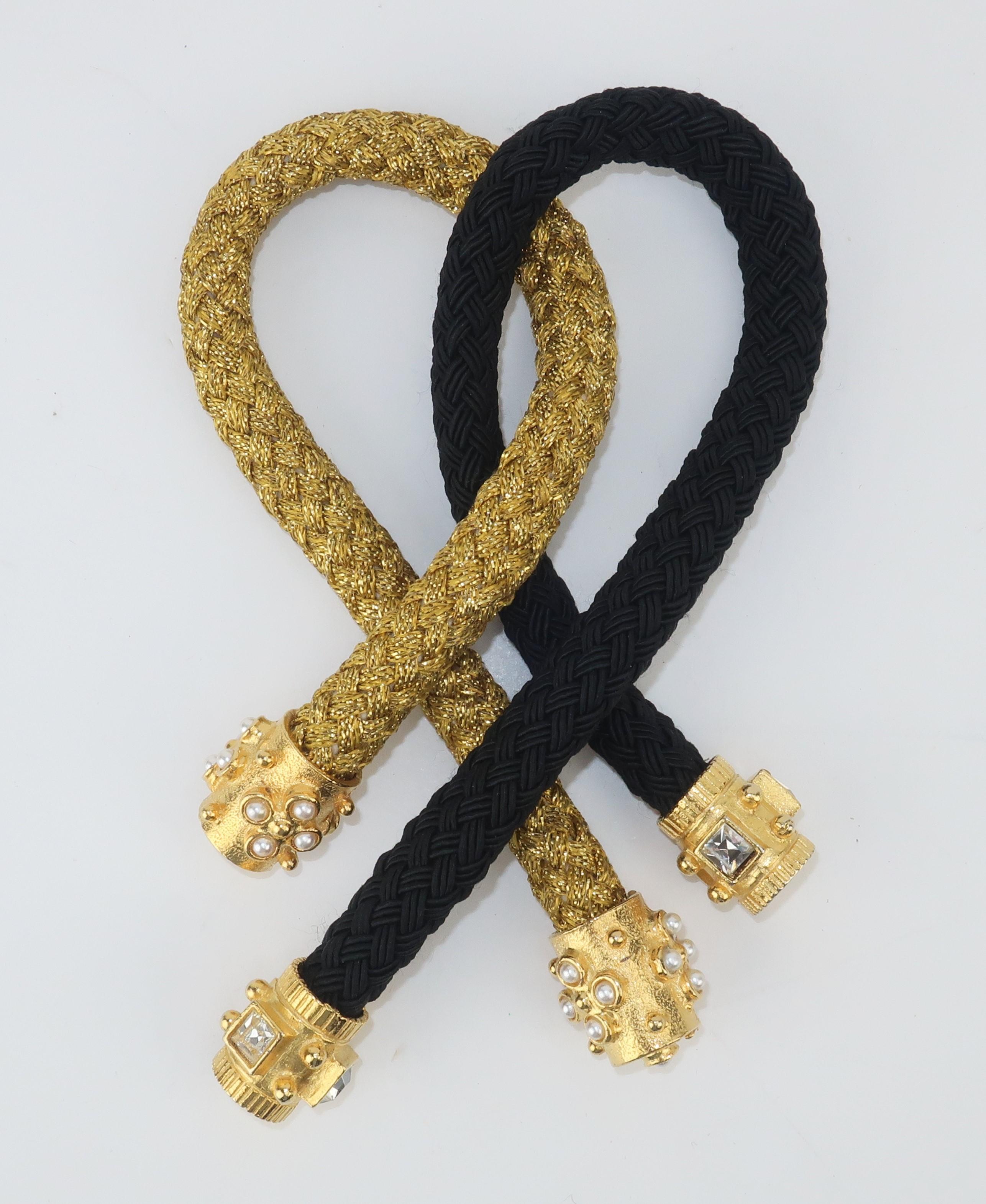 Put a little polish on your pony with these ornate hair ties.  Both pieces are braided with one in a metallic gold and the other in black.  Both are accented with weighty gold tips in a byzantine style design with one accented by pearls and the