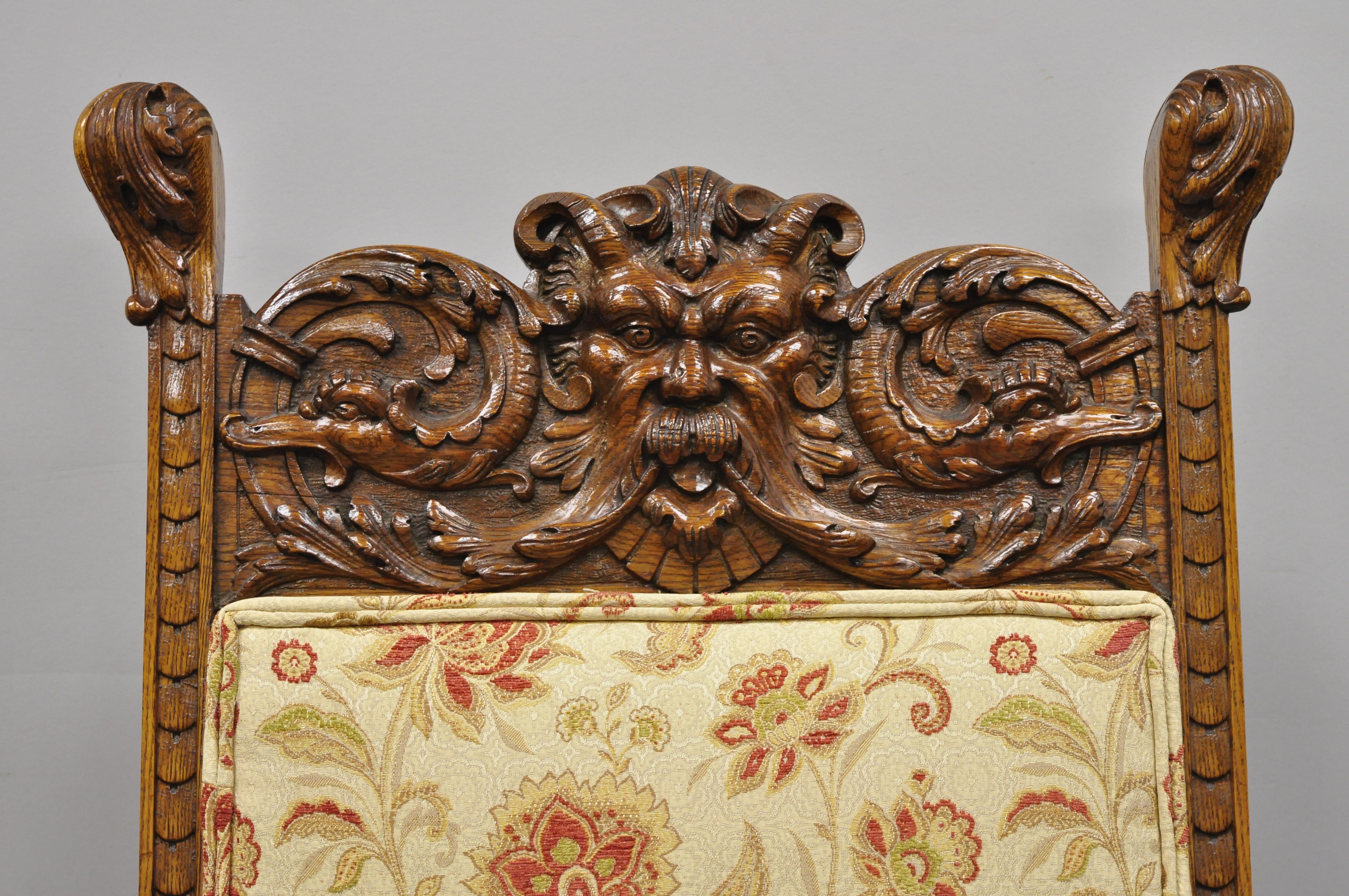 Pair to 19th century carved oak Northwind face and lion head armchairs attributed to RJ Horner. Item features carved Northwind faces to top rail, lion heads to armrests, upholstered back and seats, solid oakwood construction, finely carved details,