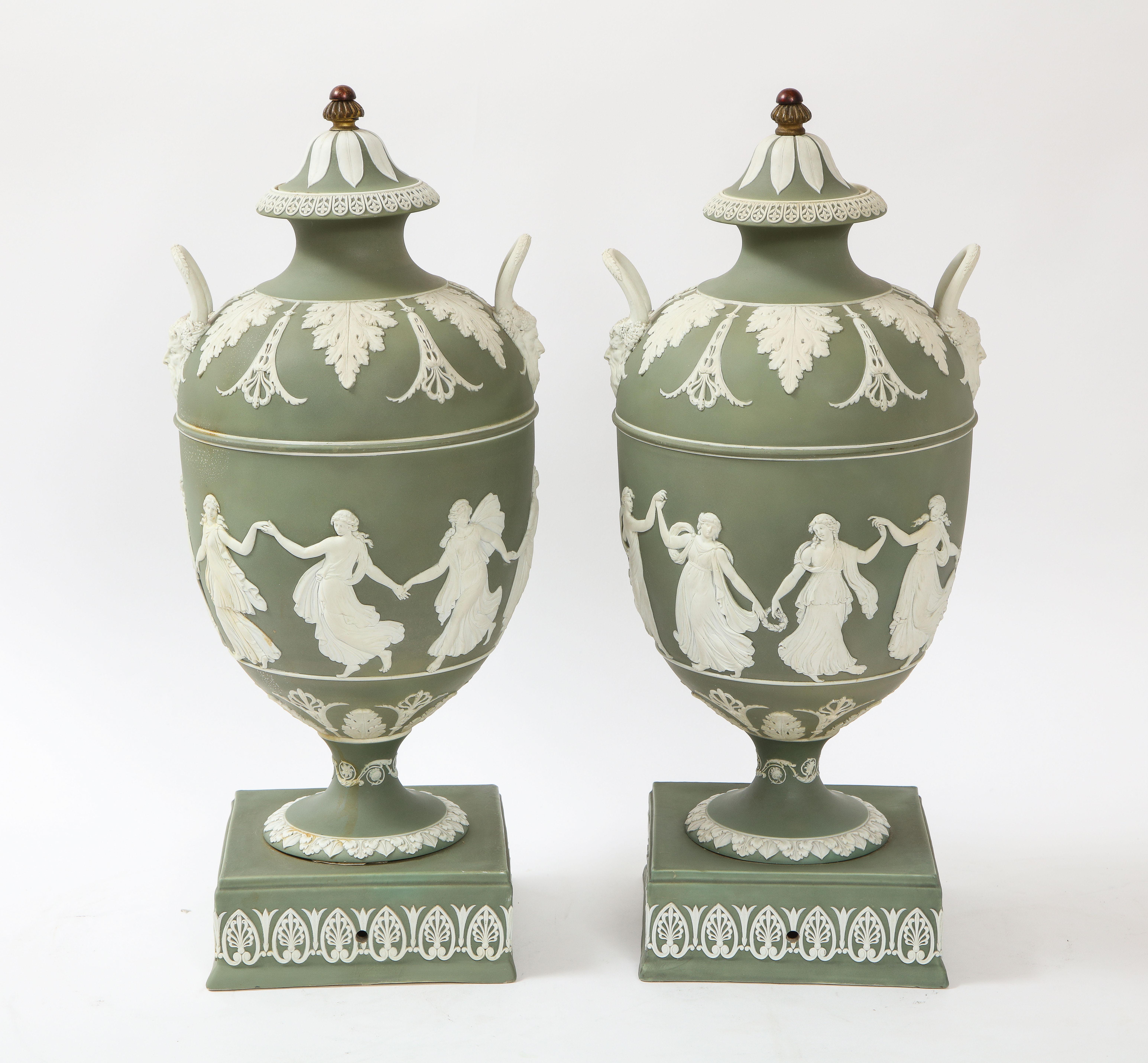 An elaborate large pair of 19th century neoclassical style olive ground covered English, Staffordshire, Jasperware Wedgwood vases with neoclassical figures in white jasperware, in the style of John Flaxman. Each of these vases is in exceptional