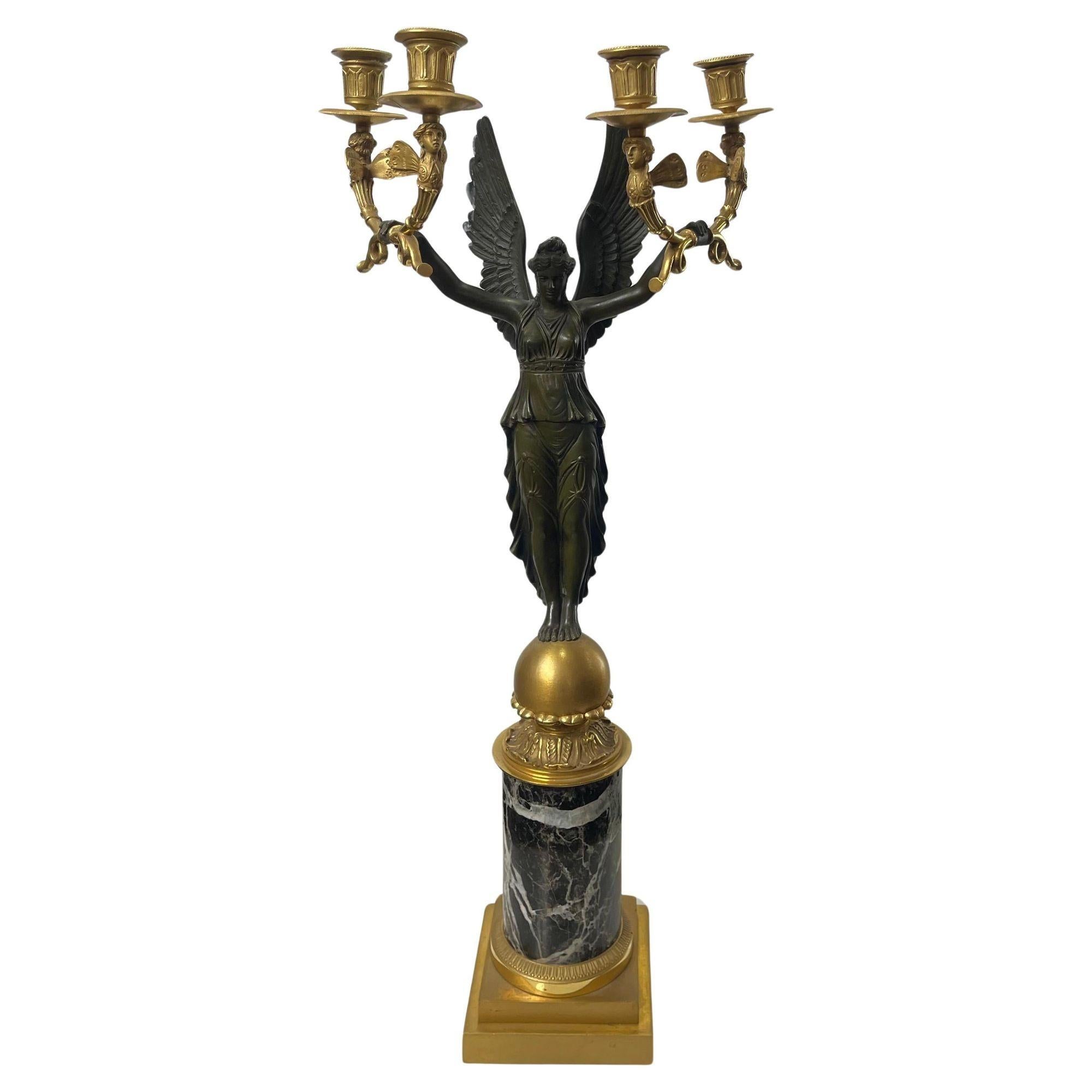 Una squisita coppia di candelabri in bronzo dorato da parcella dell'Impero francese del XIX secolo, che mette in mostra l'opulenta maestria dell'epoca. Ogni candelabro presenta una figura in bronzo patinato di una fanciulla alata, che regge con