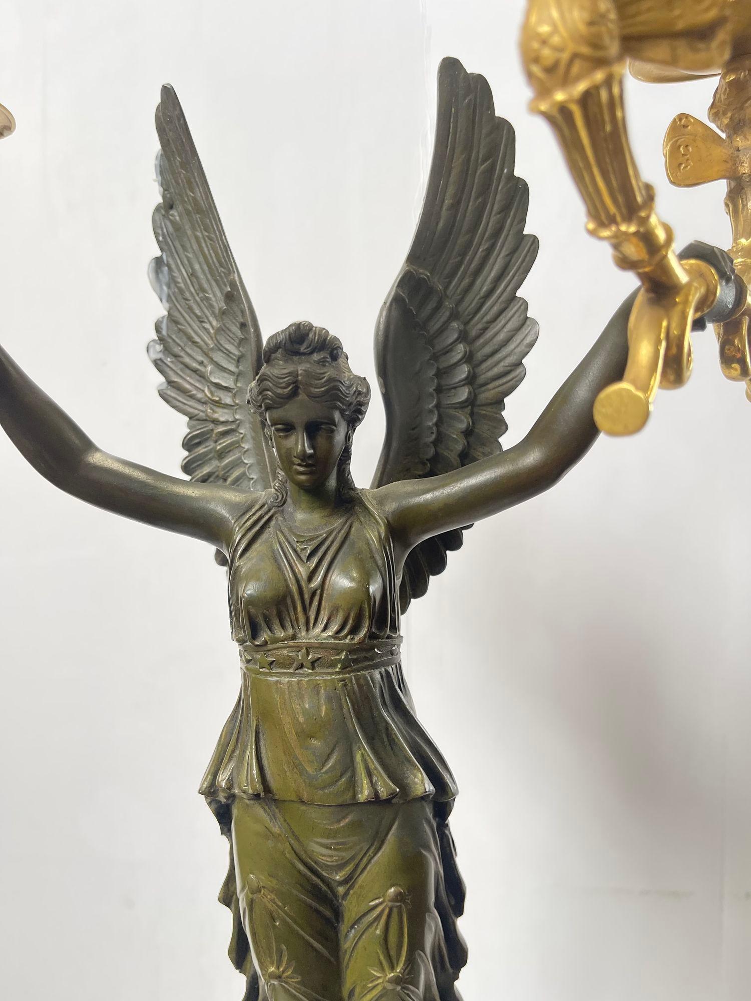 Francese Coppia di candelabri francesi impero in bronzo dorato A.I.C. con figure di fanciulle alate in vendita