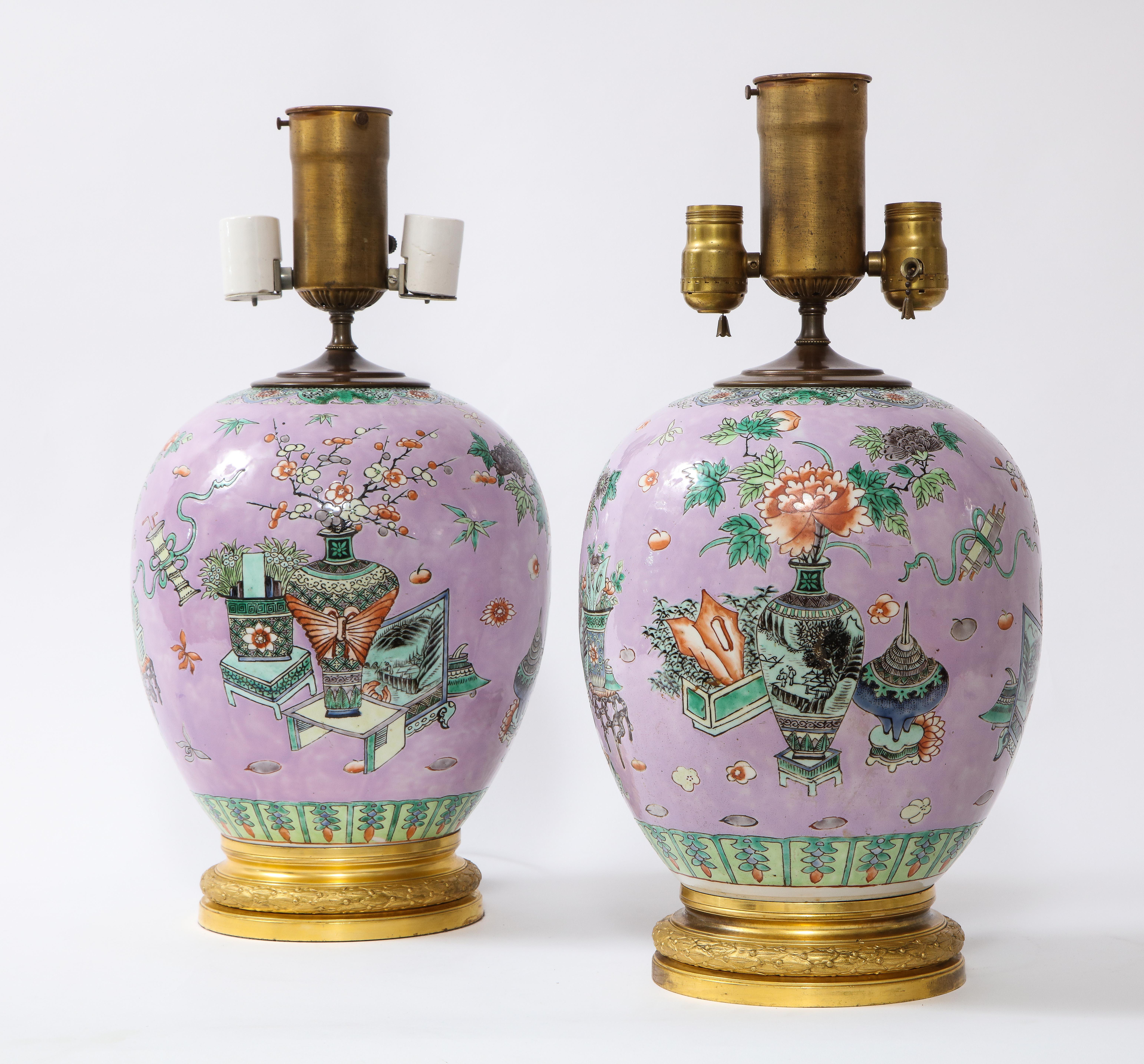 A Beautiful Pair of 19th/Early 20th Century Chinese Lavender Ground Famille Rose Decorated Porcelain Lamps on French Ormolu Mounts.  Each lamp is of bulbous form with a gorgeous light lavender ground which is very unusual for Chinese porcelain.  The