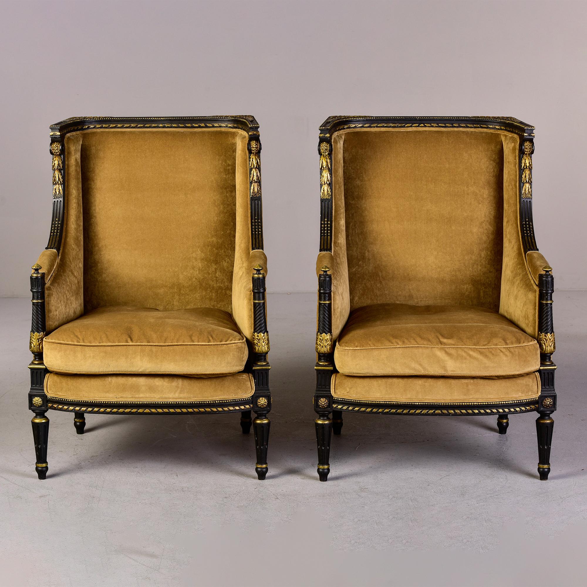 Circa 1840s pair of Louis XVI style bergeres with tall backs and winged sides, ebonised frames with lots of finely carved and gilded detail. Newly upholstered before we acquired them - the fabric is a dark camel colored chenille velvet. Unknown