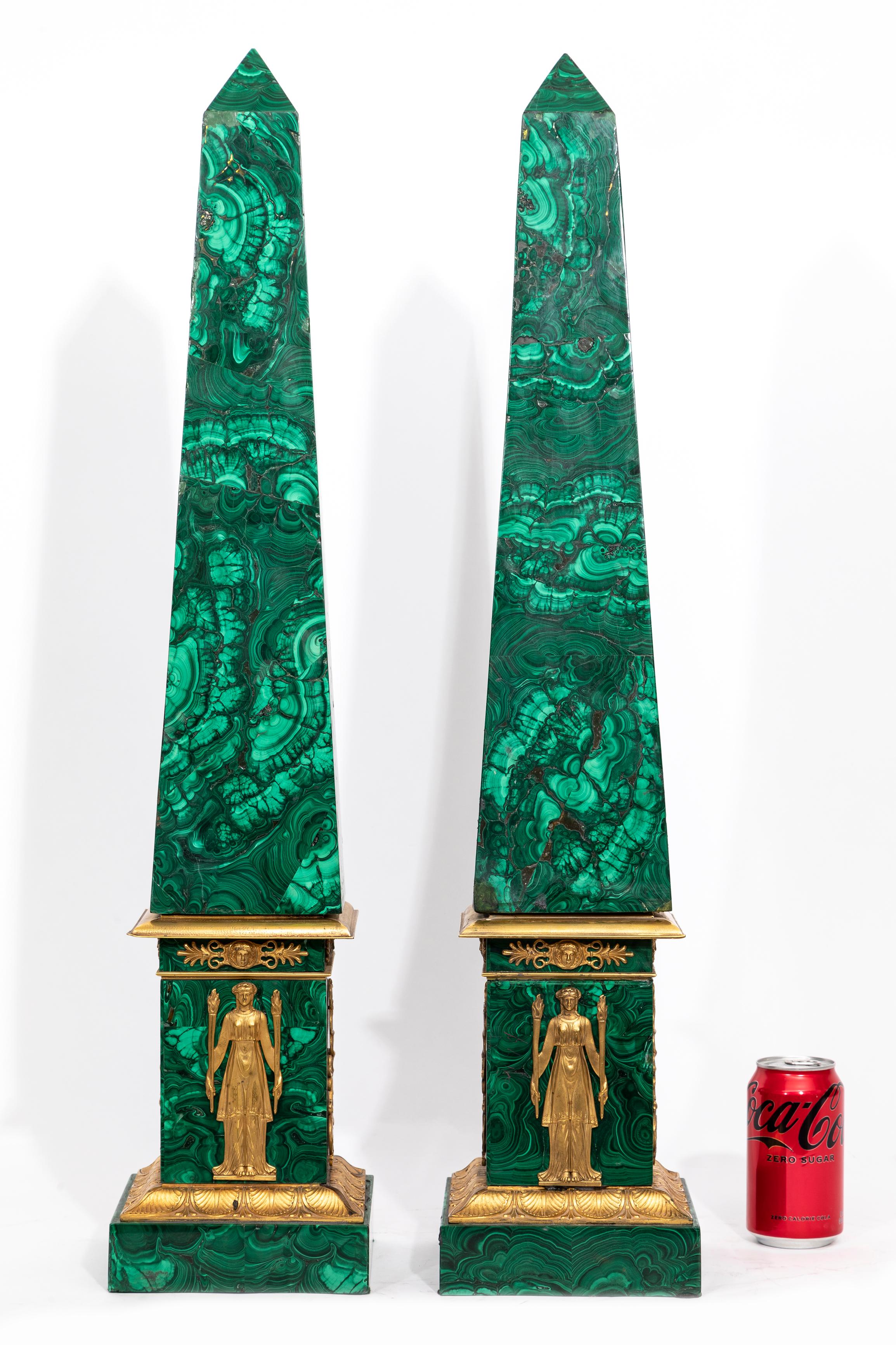 A Monumental and Quite Rare Pair of 19th Century Russian Empire Ormolu Mounted Malachite Obelisks with Maiden Ormolu Mounts.  Each obelisk is complete with four sides which terminate upwards to a triangular point.  The bases are fitted with ormolu