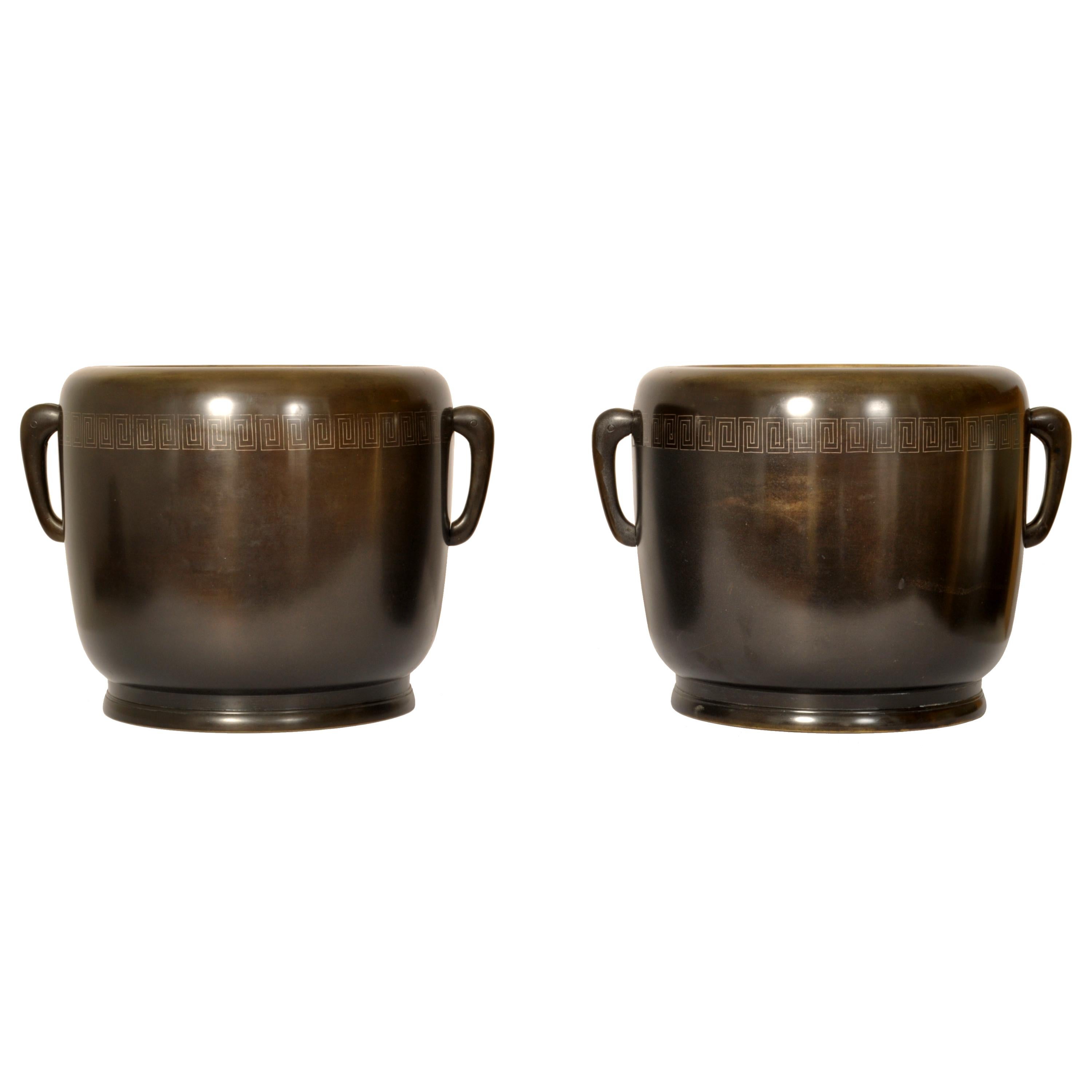 A very stylish pair of antique Japanese Meiji period (1868-1912) bronze hibachi or censers, circa 1890.
Of rounded form with a band of 'Greek key' decoration, to each side is a zoomorphic stylized elephant handle. Both censers are raised on a