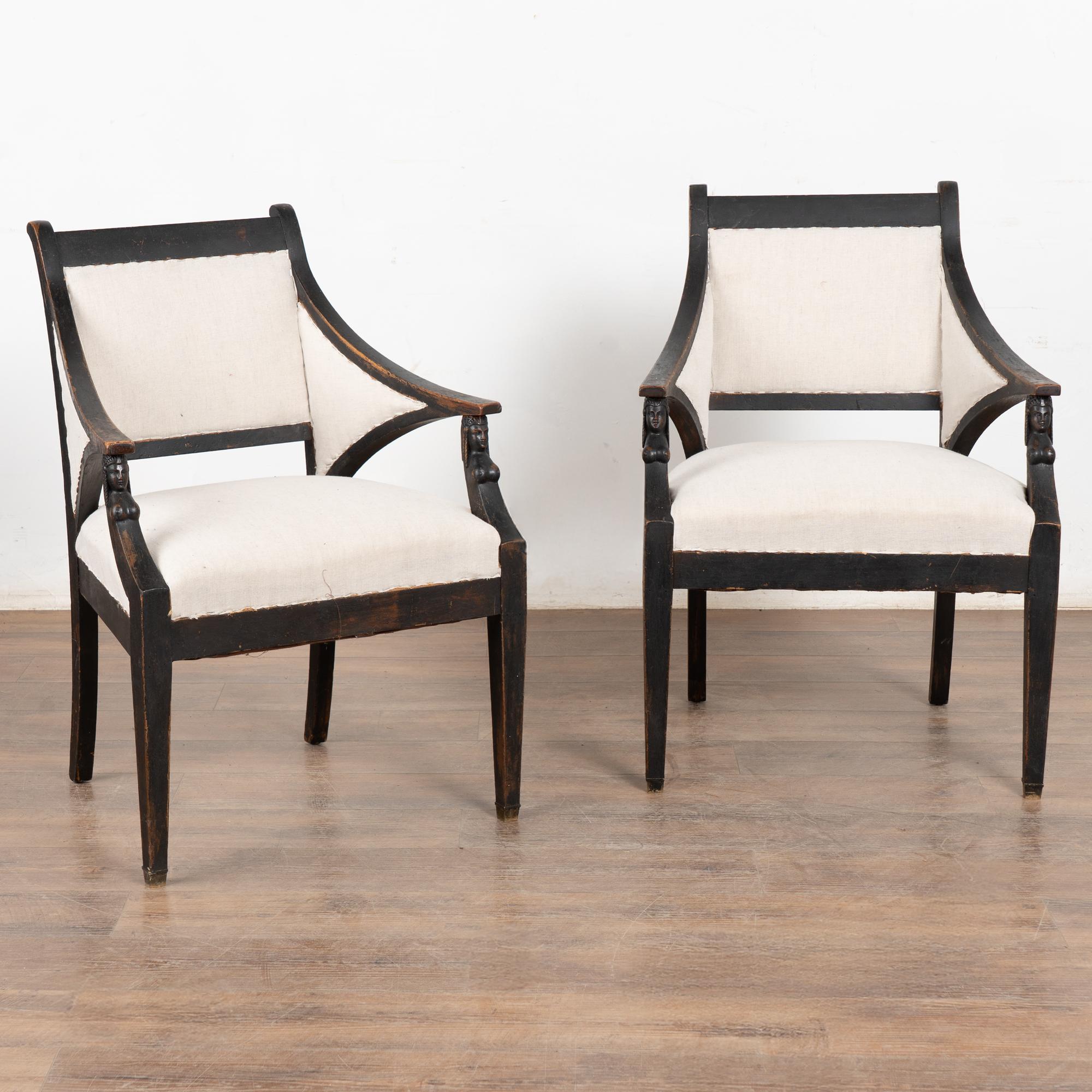 Paire de fauteuils suédois de style gustavien, dont les accoudoirs sont légèrement incurvés vers l'arrière et les pieds avant effilés, ce qui ajoute à l'attrait gracieux de chacun d'entre eux.
Des têtes sculptées distinctives ornent le devant sous