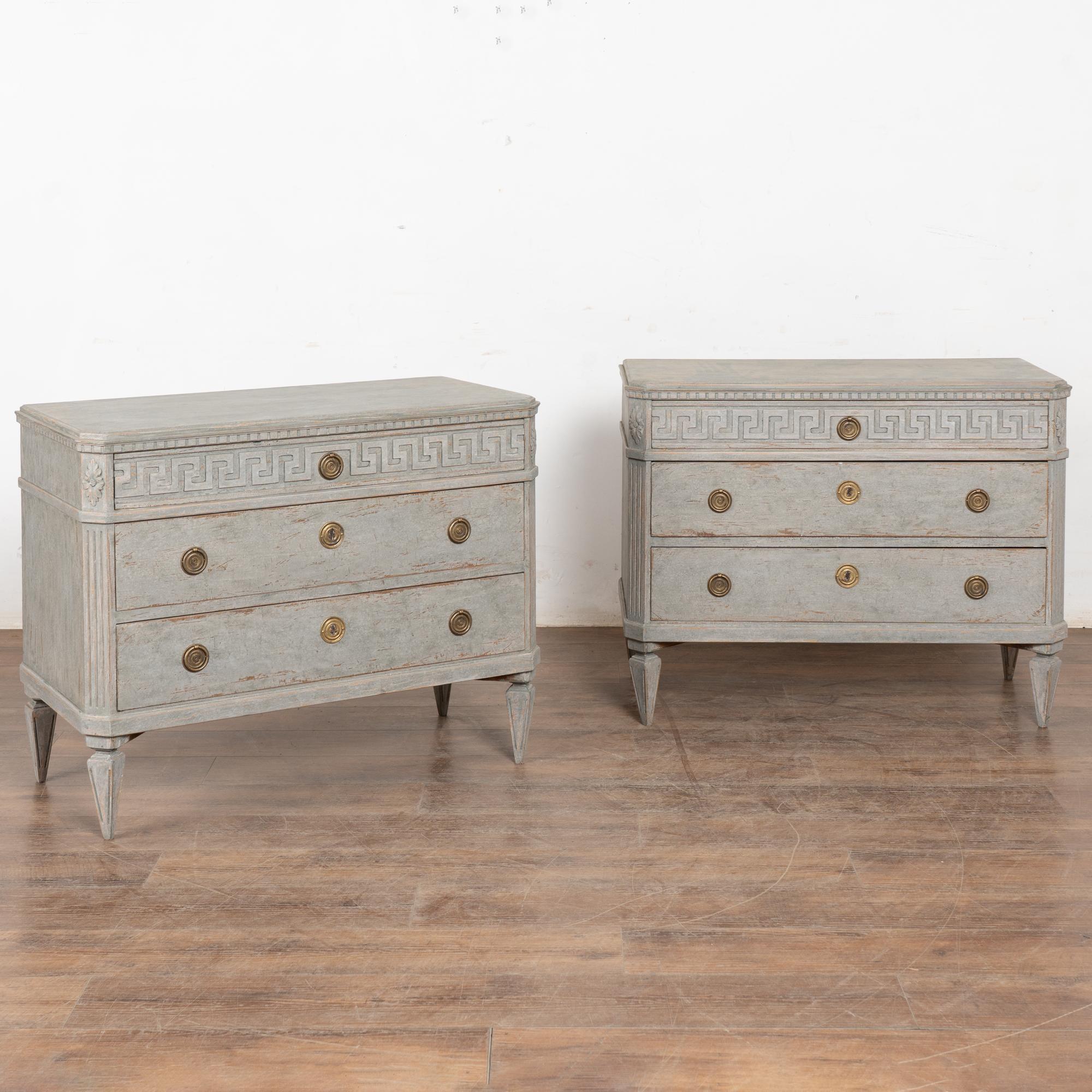 A pair of elegant Gustavian pine chest of drawers with brass pulls on each drawer.
Three drawers, upper drawer decorated with carved Greek key motif. Canted fluted side posts, dentil molding, all raised on four tapered fluted feet.
Restored and