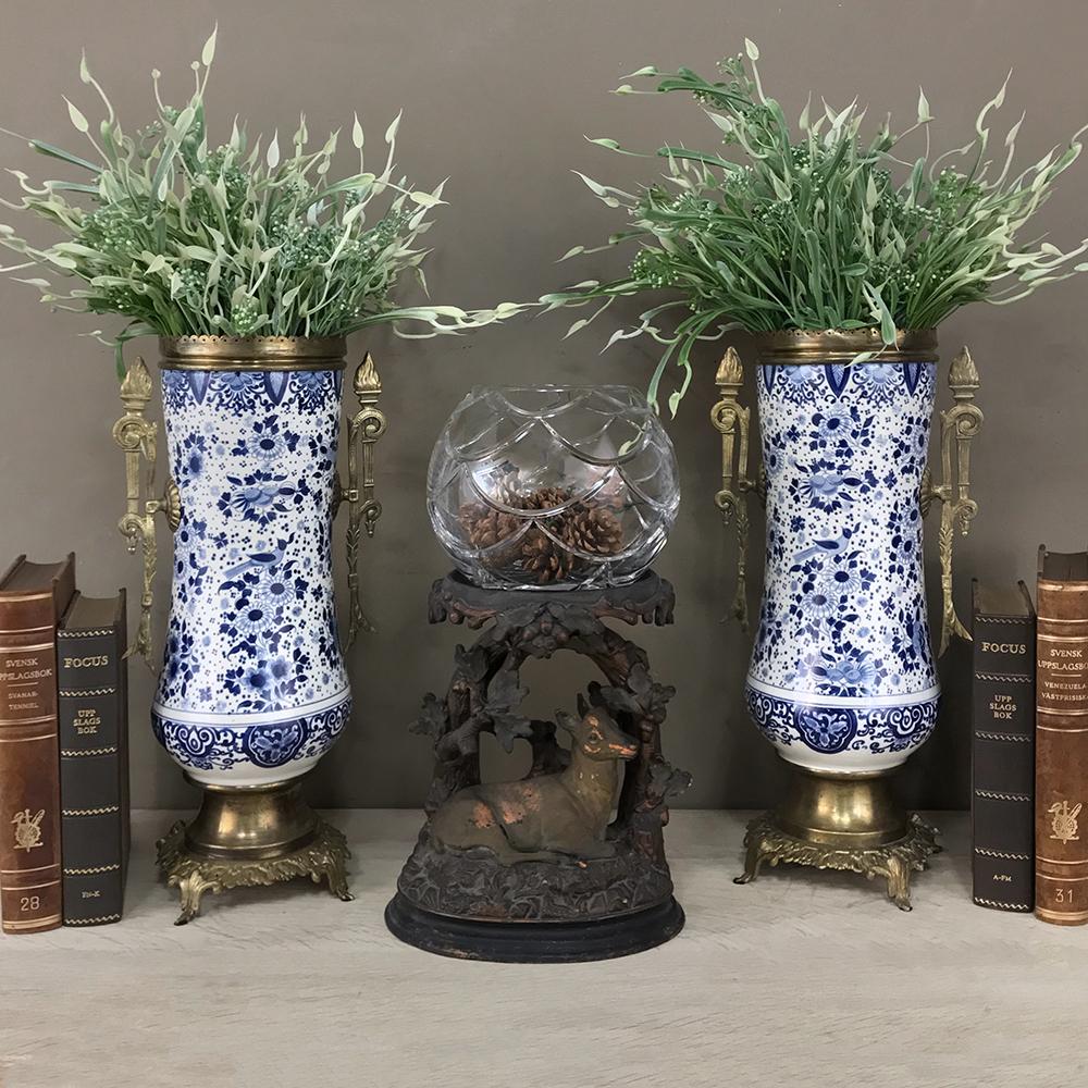 Pair of 19th century blue and white delft vases with brass feature hand painted cobalt blue patterns of avian and floral design with geometric bordering and a very graceful shape, enhanced by the bronze mounted handles, rim rail and base,
circa