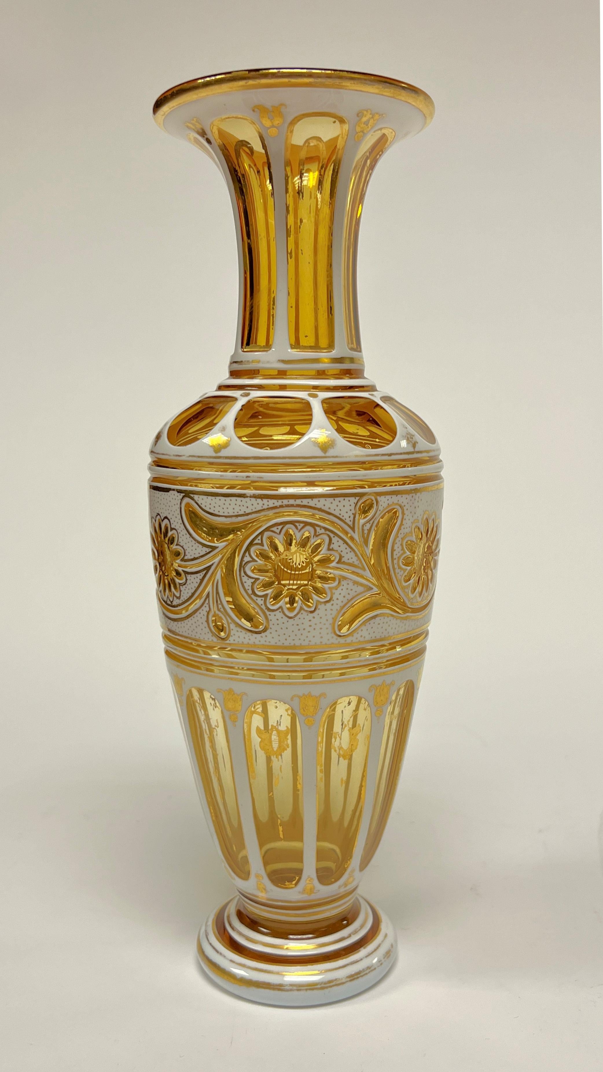 Beautiful pair of antique (late 19th century) Bohemian vases crafted from white and brilliant yellow cased glass, with the white cut to yellow, distinguished by their cut designs including vines and flower heads, fluting on the base, shoulder and