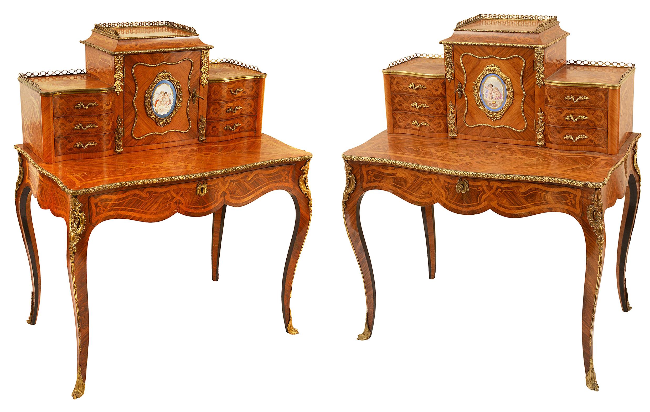 Rare pair of 19th Century French Kingwood and Tulip wood veneered Bonheur du jours, each with pierced three quarter brass galleries, gilded ormolu mounts, three drawers either side of the central door, an inset Sevres style hand painted porcelain