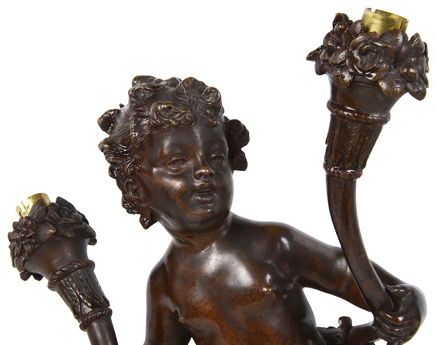 An enchanting pair of good quality 19th century patinated bronze semi clad putti, each holding cornucopia. Raised in turned moulded Rouge marble bases.
Electrified with two bulbs to each.
Signed and stamped.
 