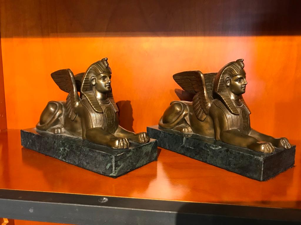 Pair French grand tour bronze sphinxes with wings mounted on green marble rectangular bases. Finished with a warm golden hued patina. Will make a fine pair of bookends or stand alone decoration.
Greta for a mantle piece, den, library or bookshelf.