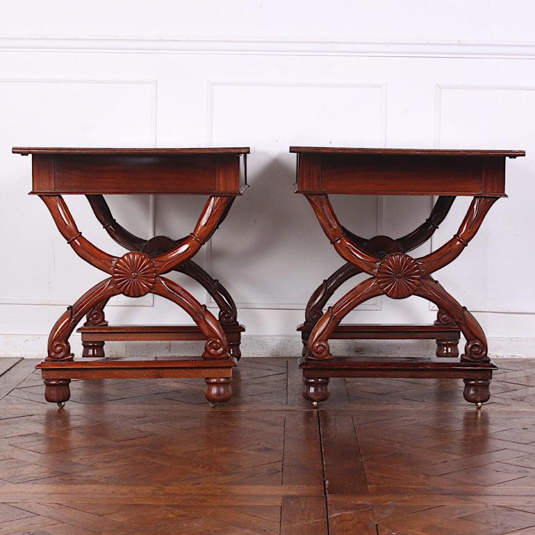 Pair of French empire carved mahogany consoles, the solid mahogany tops raised on Empire style ‘X’ scroll-carved legs joined by a stretcher. 

 