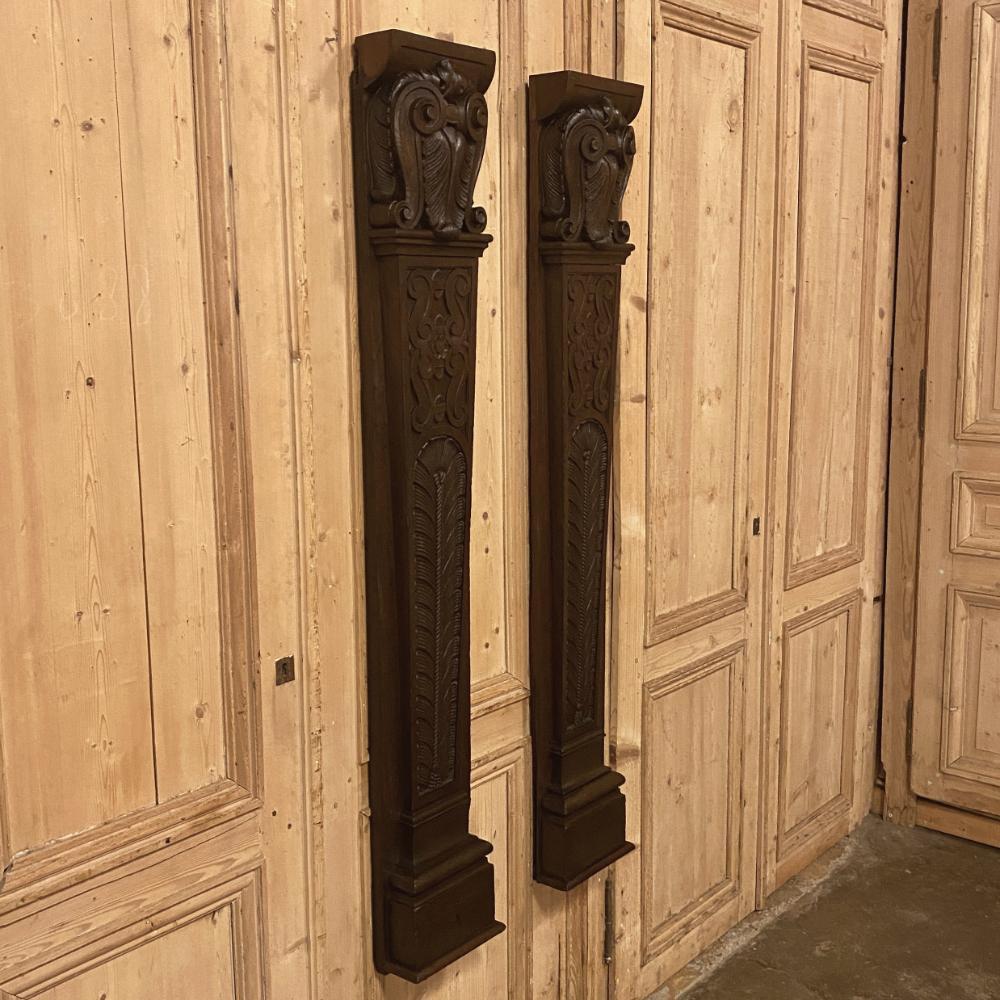 Pair 19th century carved pilasters are classically inspired with columns carved with fletching and an intriguing variation on the Corinthian capital above combining acanthus plumes with bold scrolls in a most unique crest-like motif! Ideal for