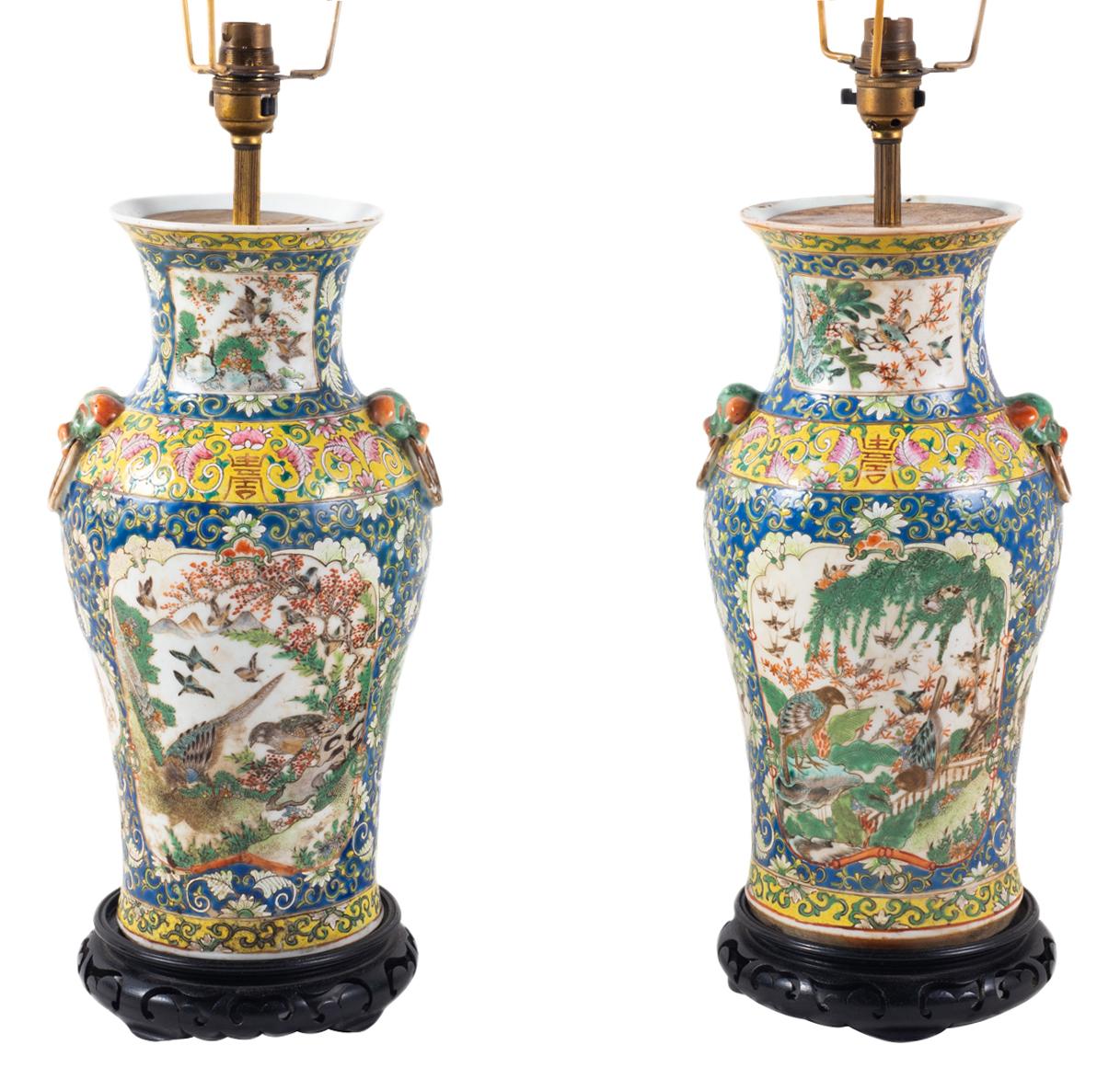 A very good quality pair of 19th Century Chinese Cantonese vases, having a blue and yellow ground with classical motif and scrolling foliate decoration around inset hand painted panels depicting exotic birds and trees, each with dog of foe mask and