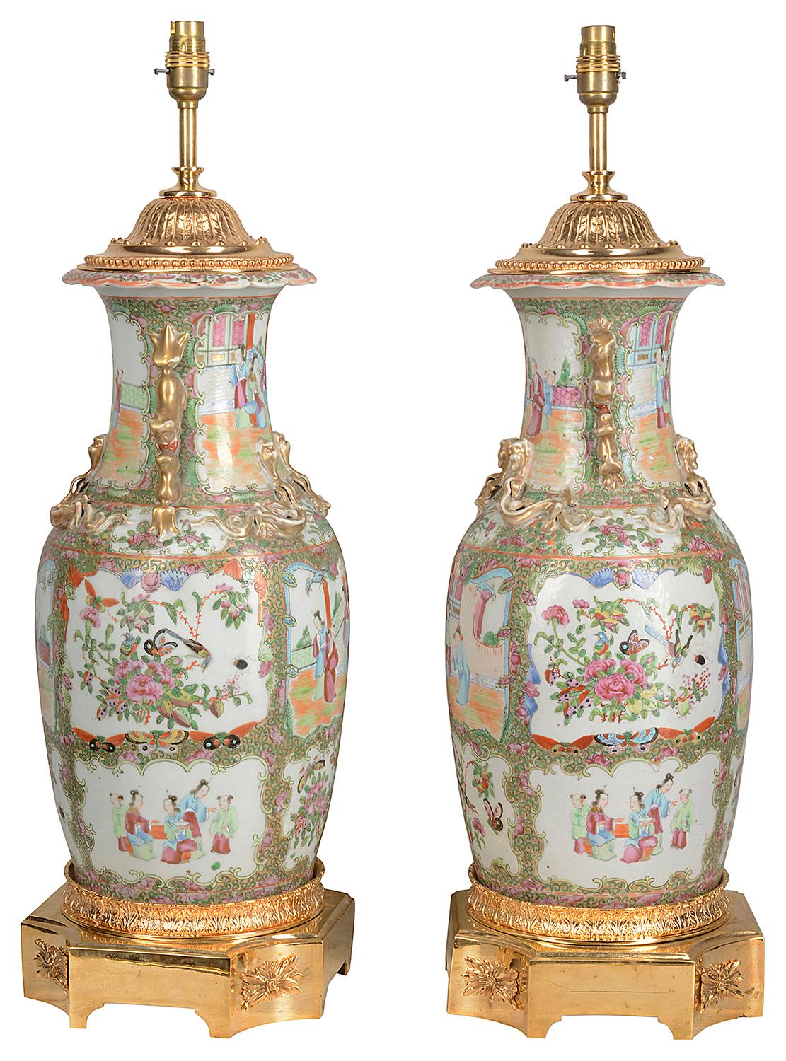 A good quality pair of 19th century Chinese rose medallion porcelain vases / lamps, each with green ground with in set hand painted panels depicting classical scenes of Geisha girls and courtiers walking around the grounds of a temple. Gilded