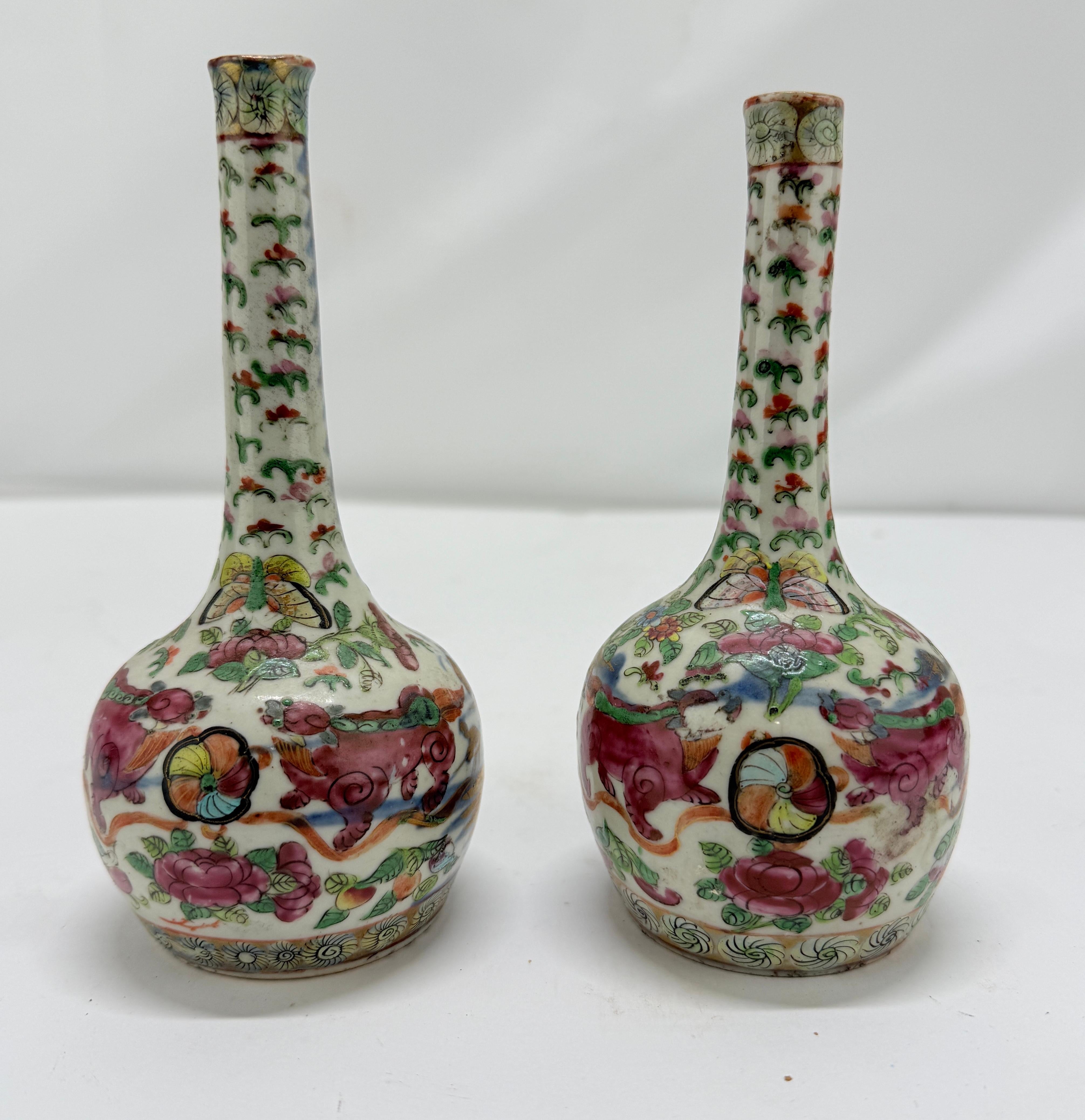 This is a pair of finely enameled Chinese porcelain vases, likely produced in the late Qing Dynasty, circa late 19th century, in the famille rose palette with additional gilt embellishment. Each vase is of elongated bottle form with a slender,