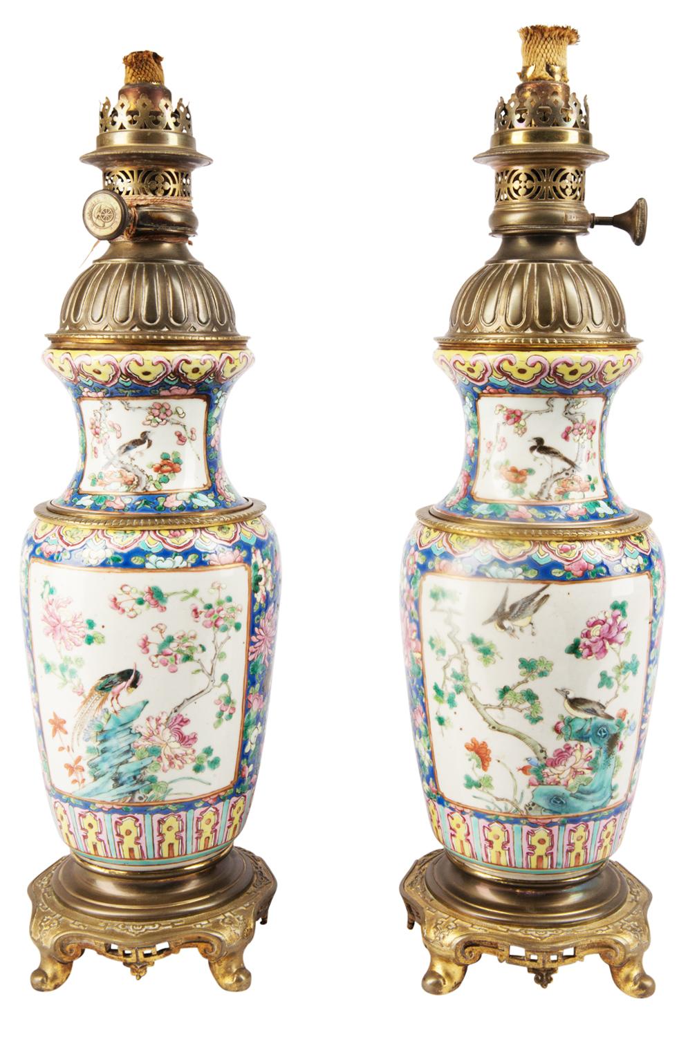 A good quality pair of Chinese 19th century Famille rose vases / lamps. Each with a blue and yellow ground, panels depicting exotic birds and flowers. Gilded ormolu lids and bases in the form of oriental hardwood stands.